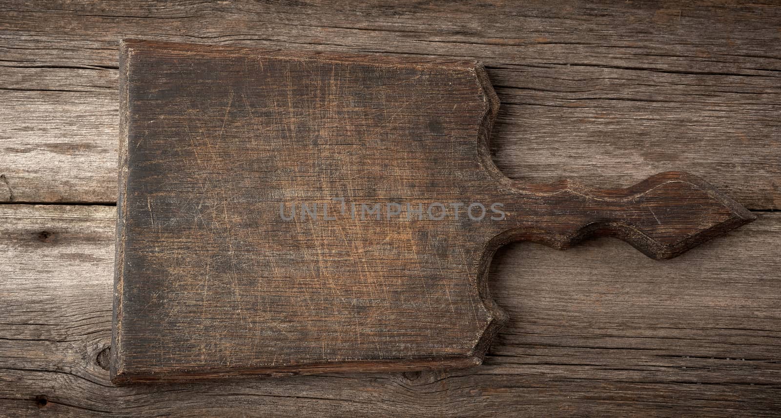 very old empty wooden cutting board, top view, gray wooden background 