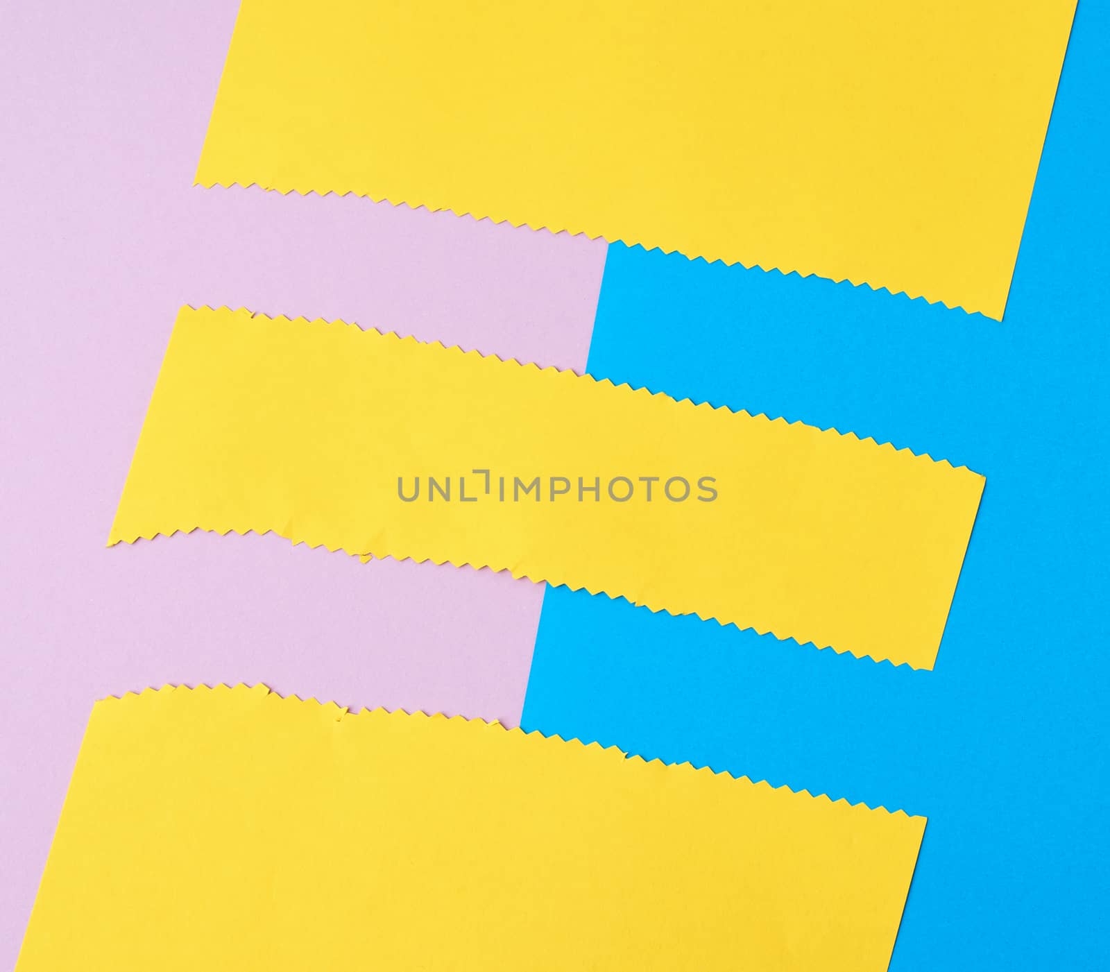 abstract background of colored paper, yellow stripes with a zigzag end, top view
