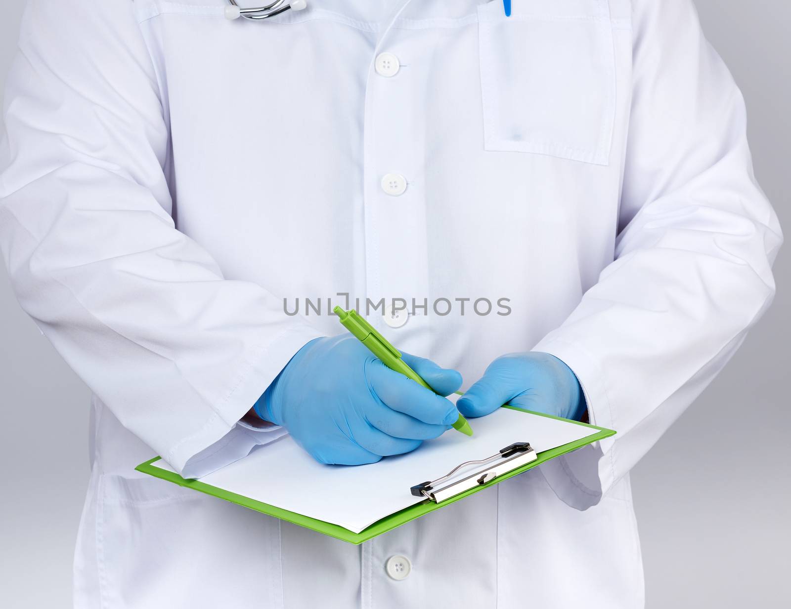 doctor in a white coat and medical blue gloves records a patient’s medical history, close up