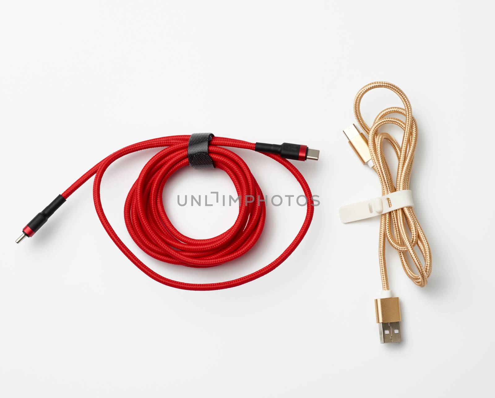 twisted cable for charging mobile devices in a red and golden textile wrapper on a white background