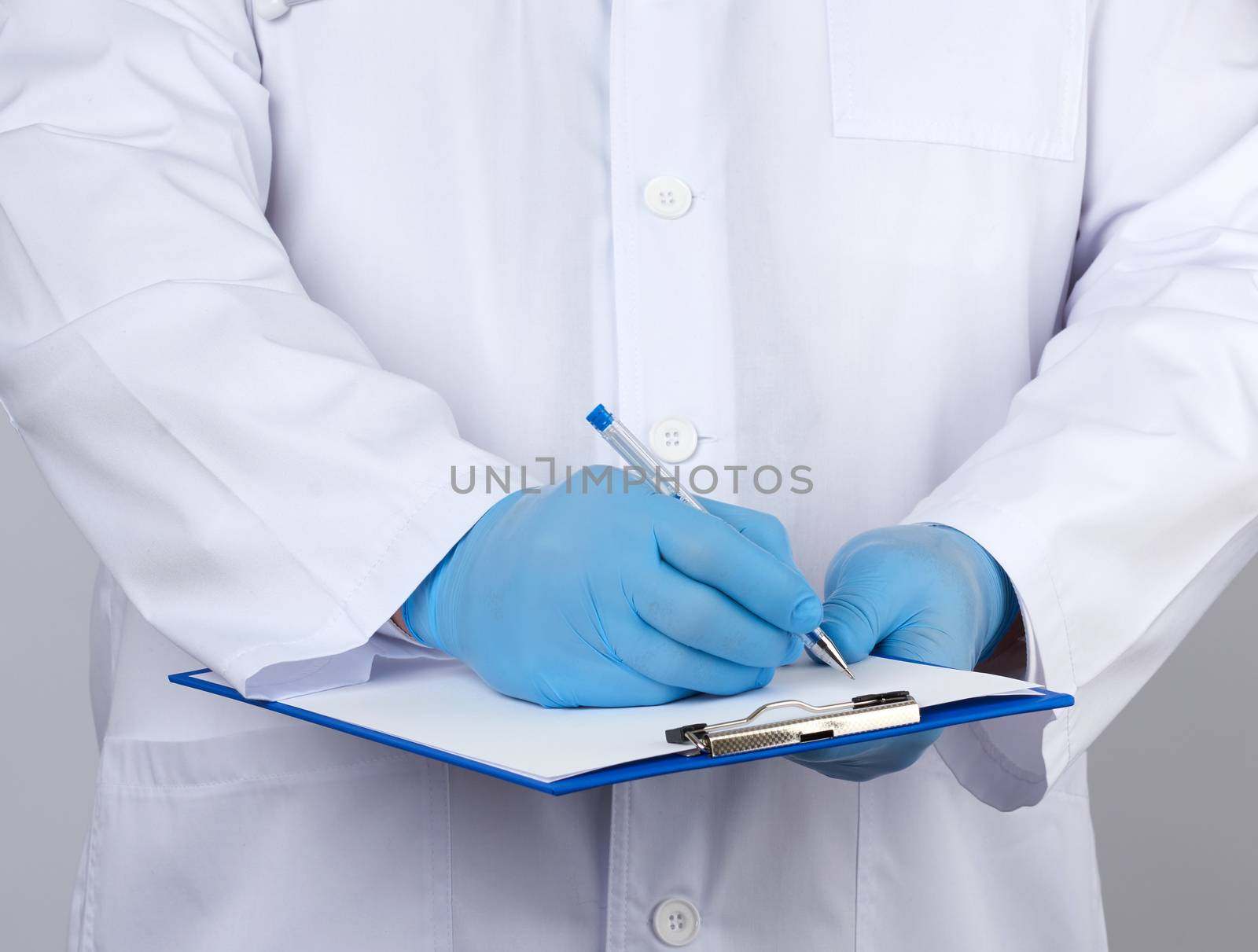 doctor in a white coat and medical blue gloves records a patient’s medical history, close up