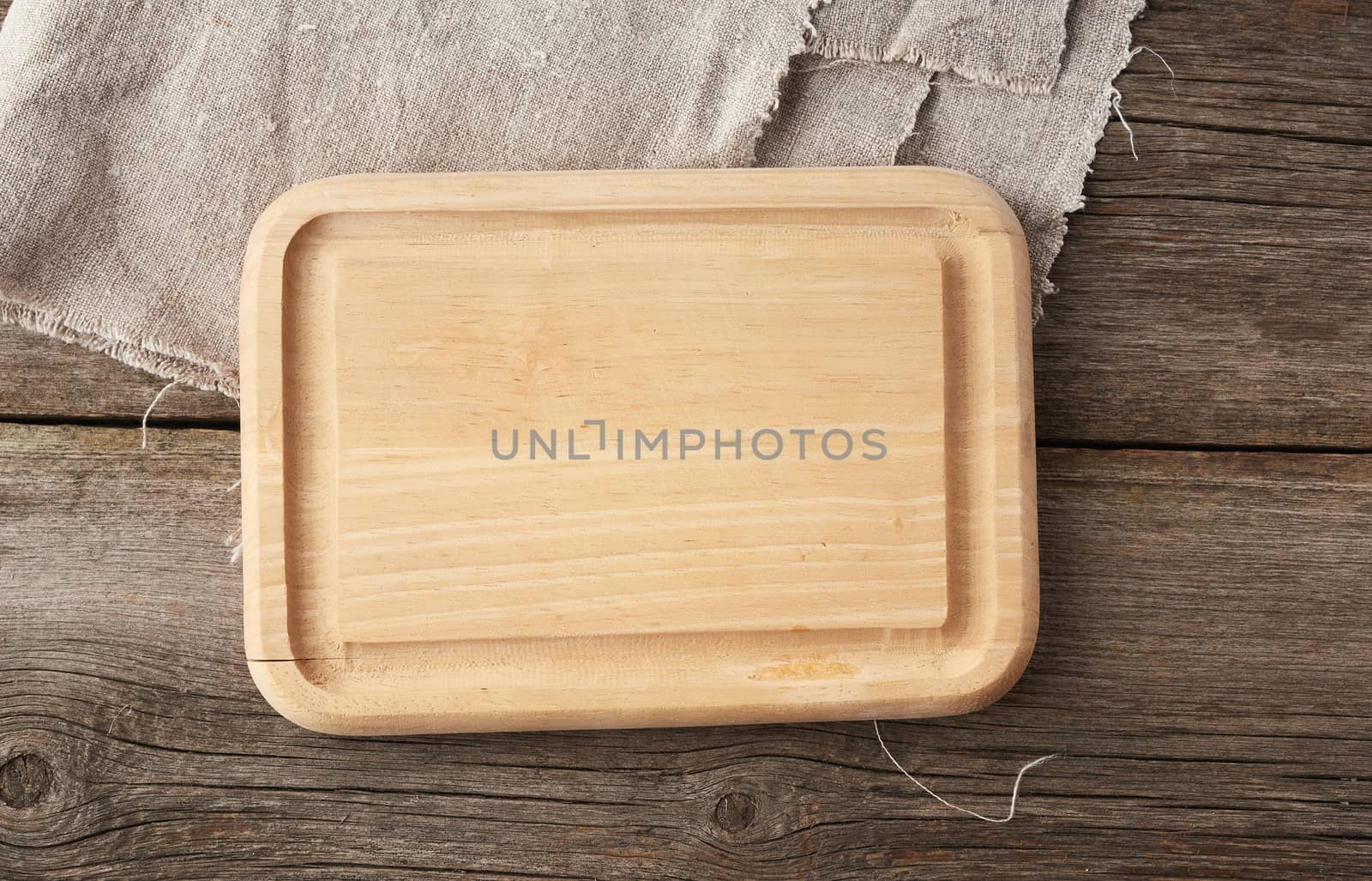 light beige rectangular empty cutting kitchen board on a wooden background from old boards, top view