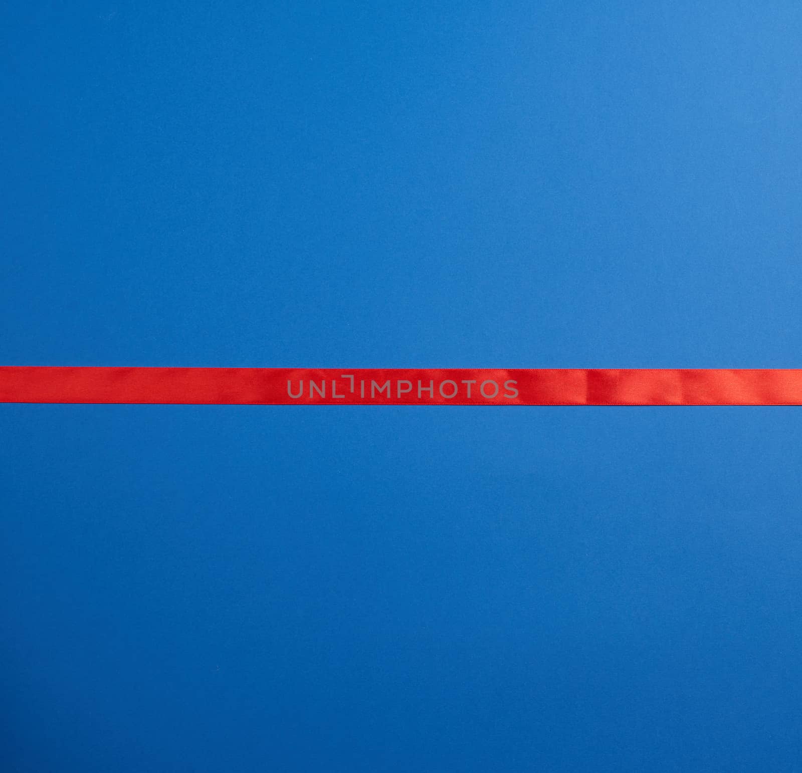 line red silk ribbon lies on a blue background, element for a designer