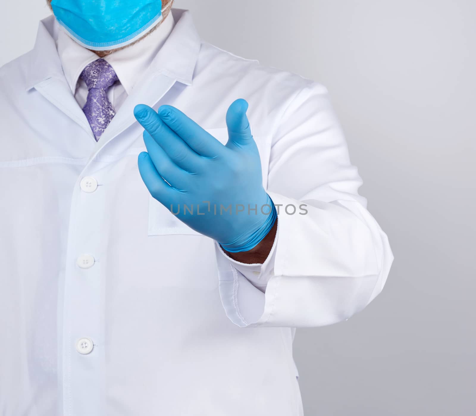doctor in a white coat with buttons and blue latex gloves holds out his hand forward, concept of invitation, handshake, white background
