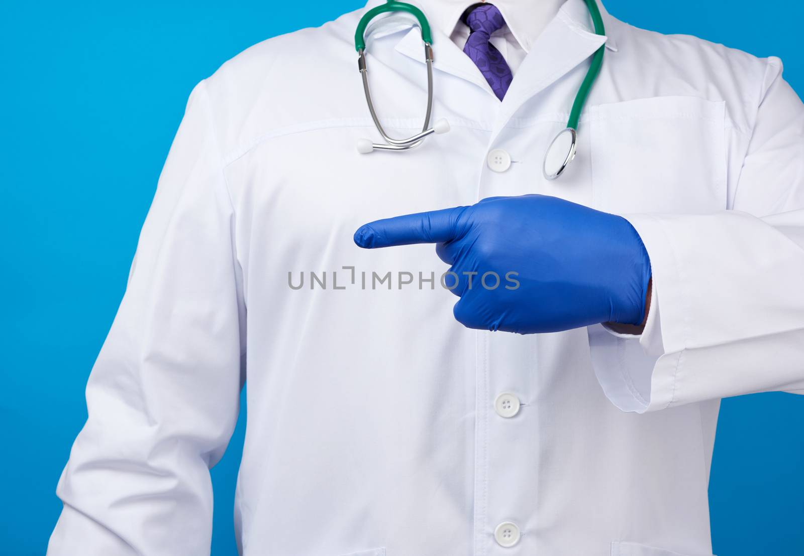 medic man in white coat with buttons, on hands wearing blue sterile gloves, showing hand gesture indicating the subject, white background