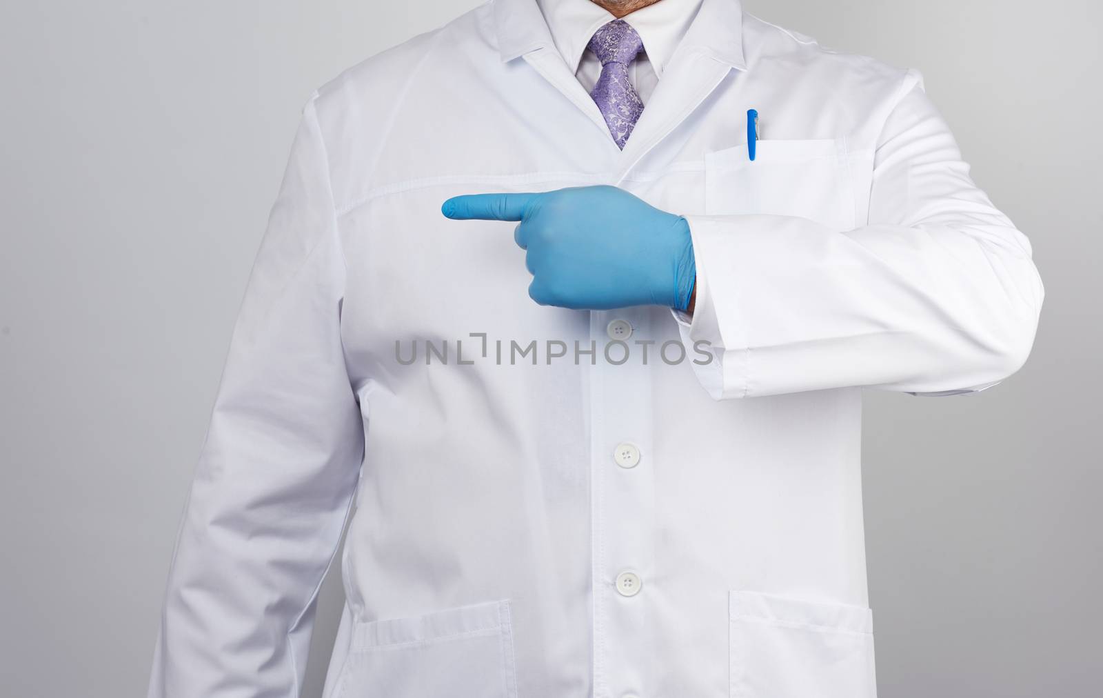 medic man in white coat with buttons,  on  hands wearing blue sterile gloves, showing hand gesture indicating the subject, white background