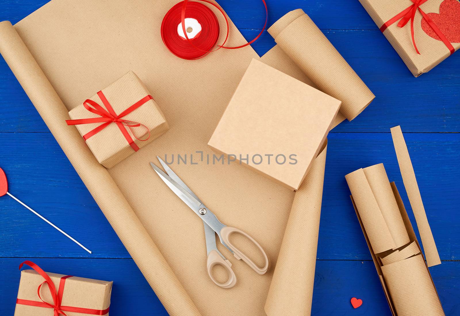brown kraft paper, packed gift bags and tied with a red ribbon, red heart, set of items for making gifts with your own hands. Gift wrapping. Package design