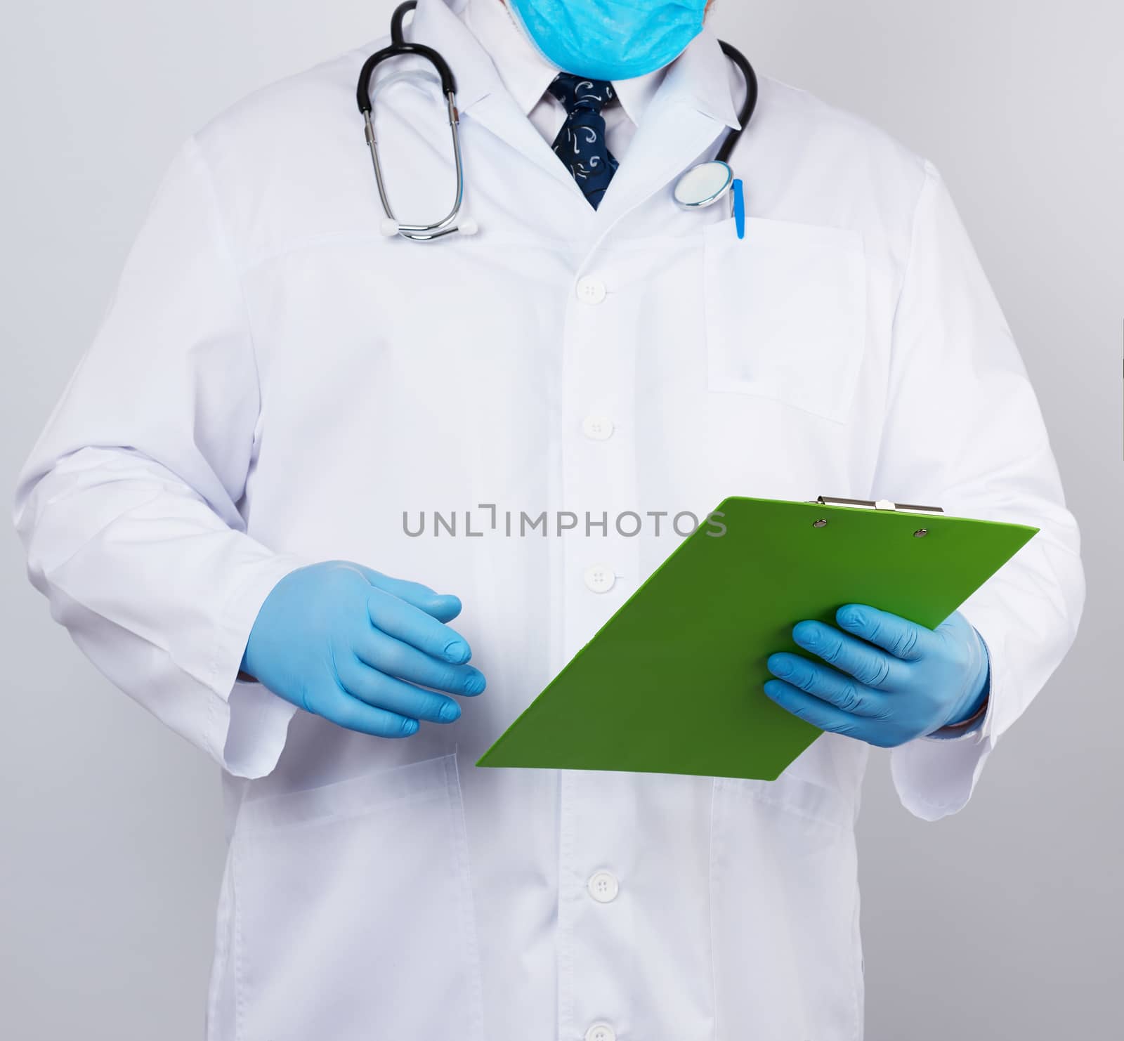 male doctor in a white coat, blue latex gloves,  stethoscope hanging on his neck,  holding a paper holder 
