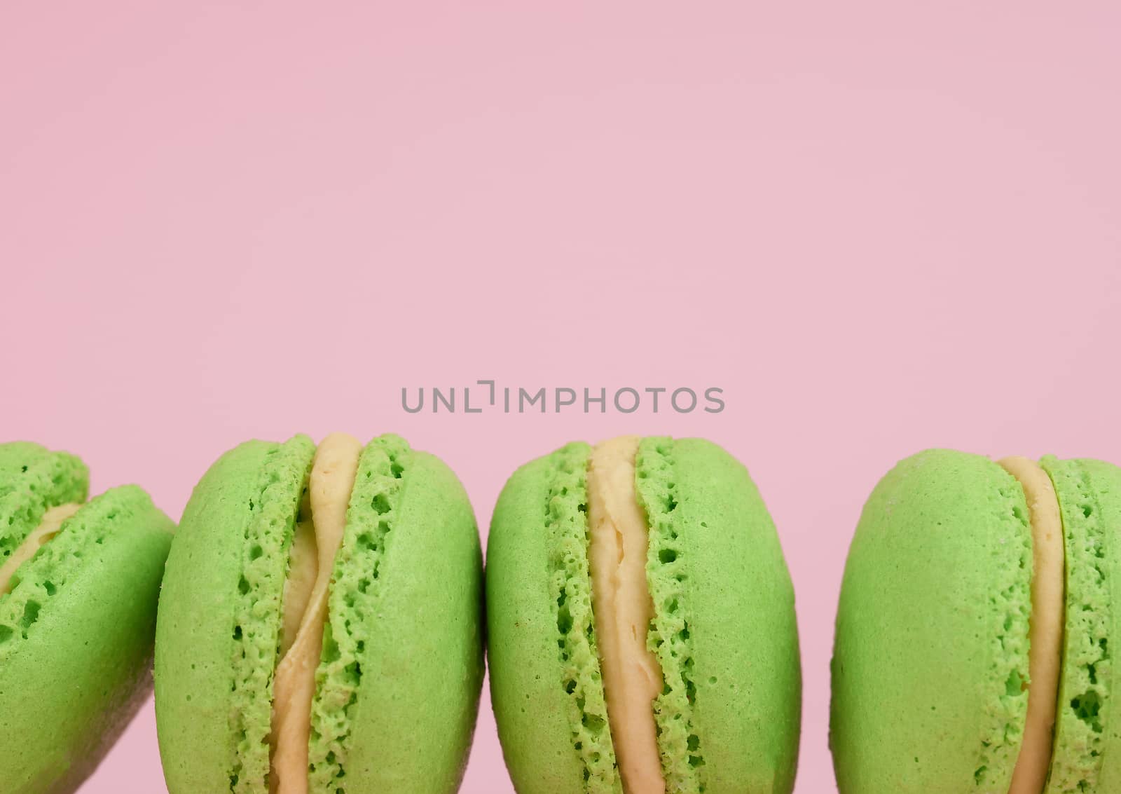 green round baked macaroon macarons on a pink background, delicious popular french dessert, copy space