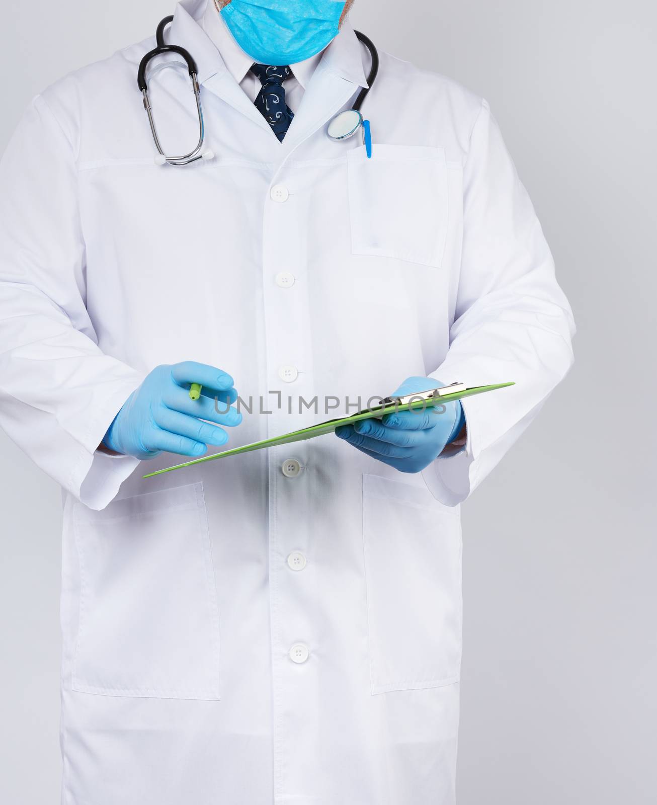 doctor in a white coat and medical blue gloves records a patient’s medical history, close up