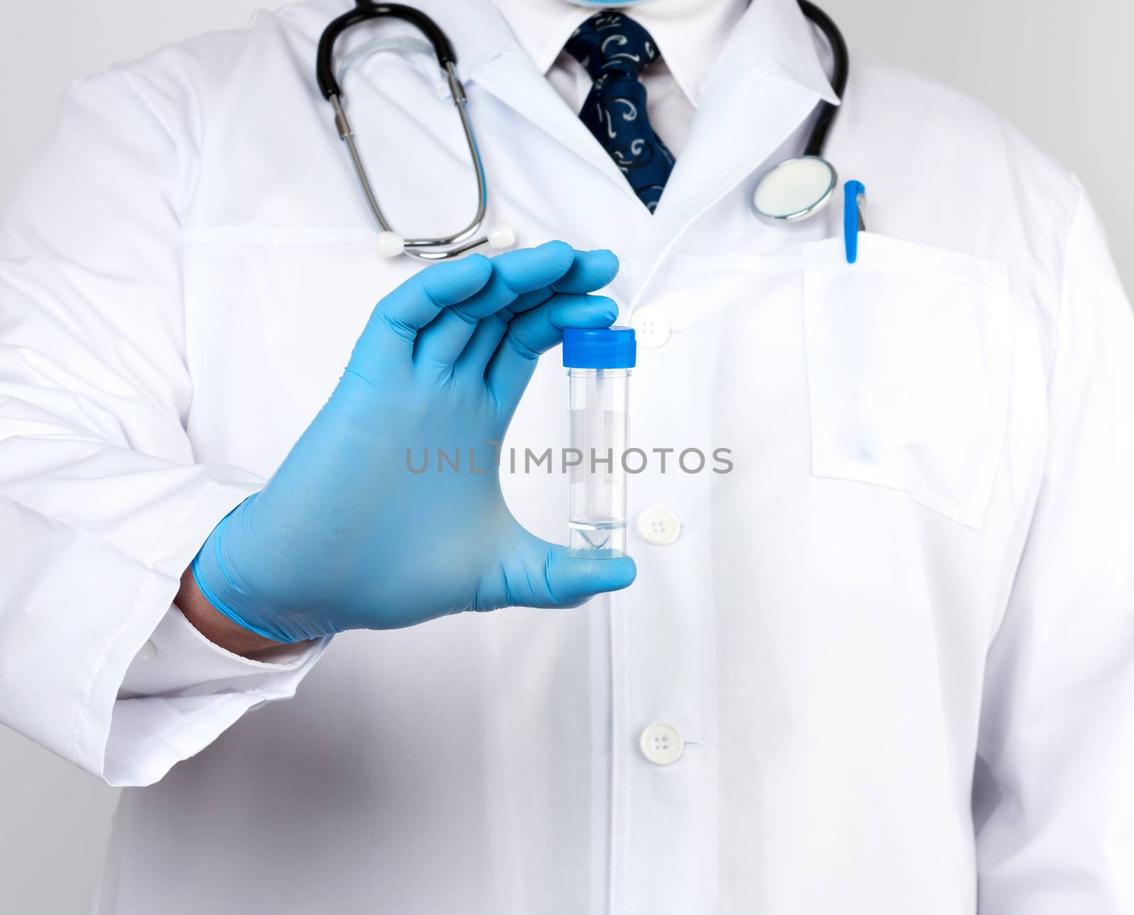 doctor in a white coat and blue sterile latex gloves holds a plastic jar for stool analysis, white background