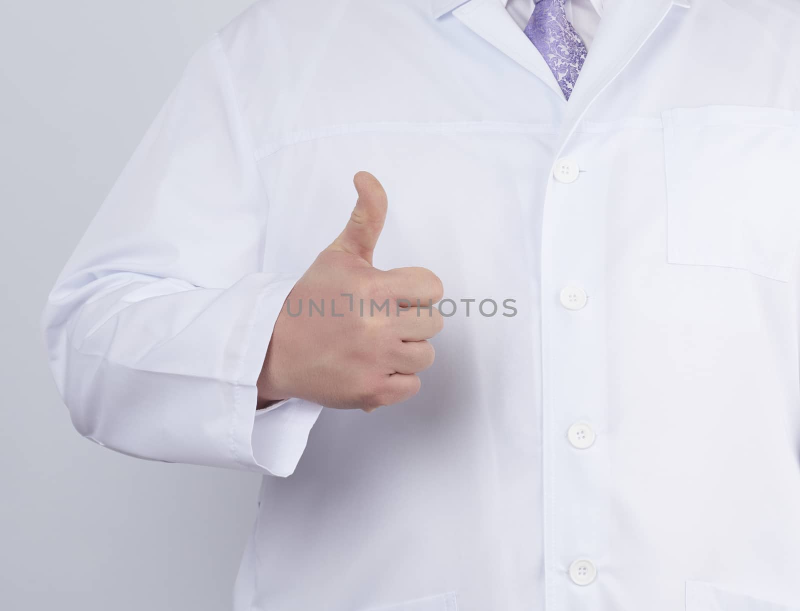 doctor in a white coat and tie shows with his hand a gesture like, white background, close up