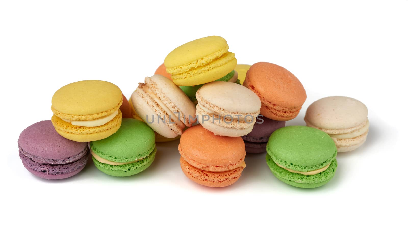 round baked multi-colored almond flour cakes macarons, dessert is laid out in a stack and isolated on a white background