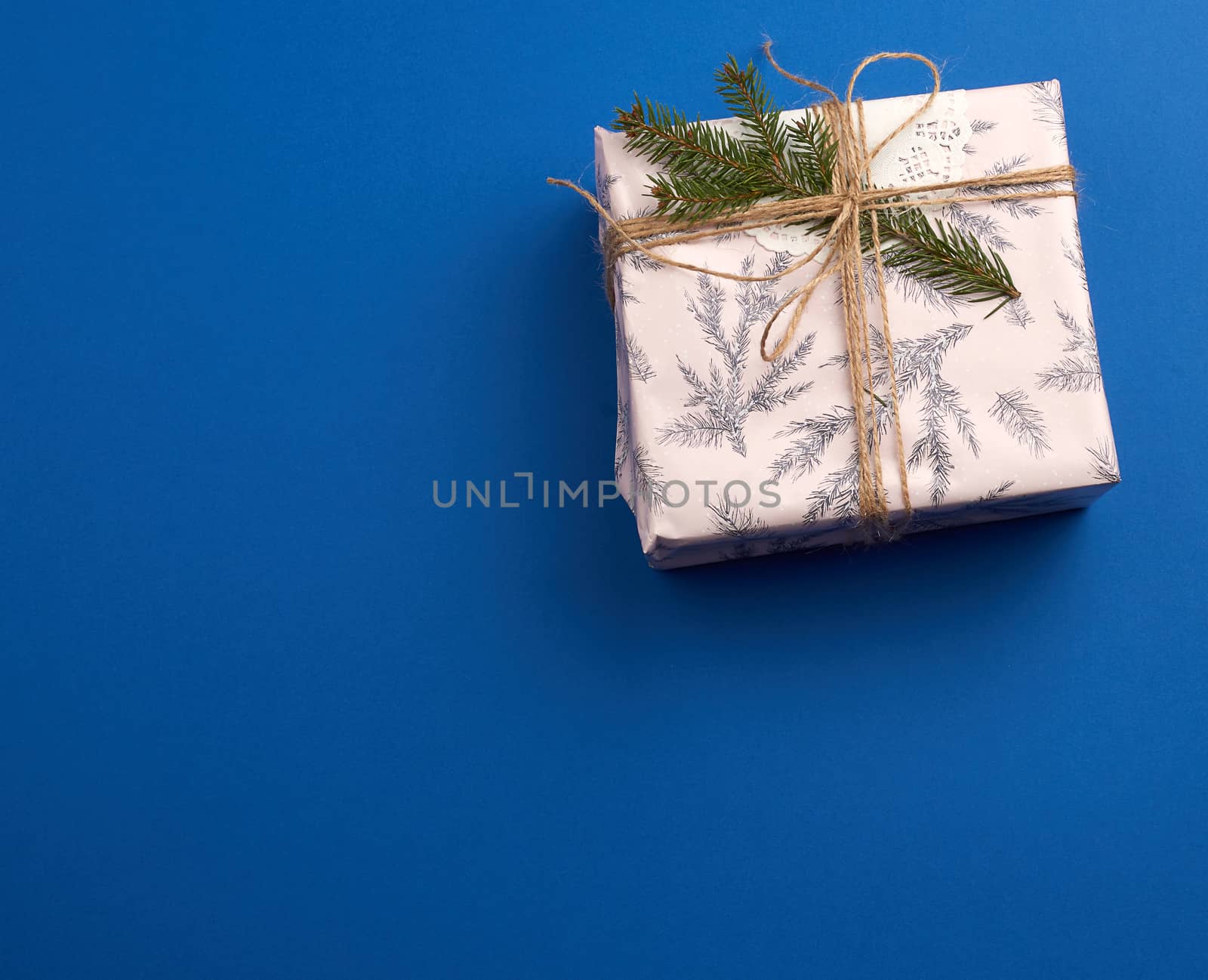pink wrapped gift boxes and tied with a brown rope, dark blue holiday backdrop