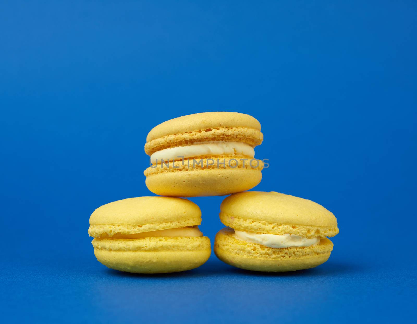 yellow lemon round baked macaroon cakes on a dark blue background, sweet dessert,  close up