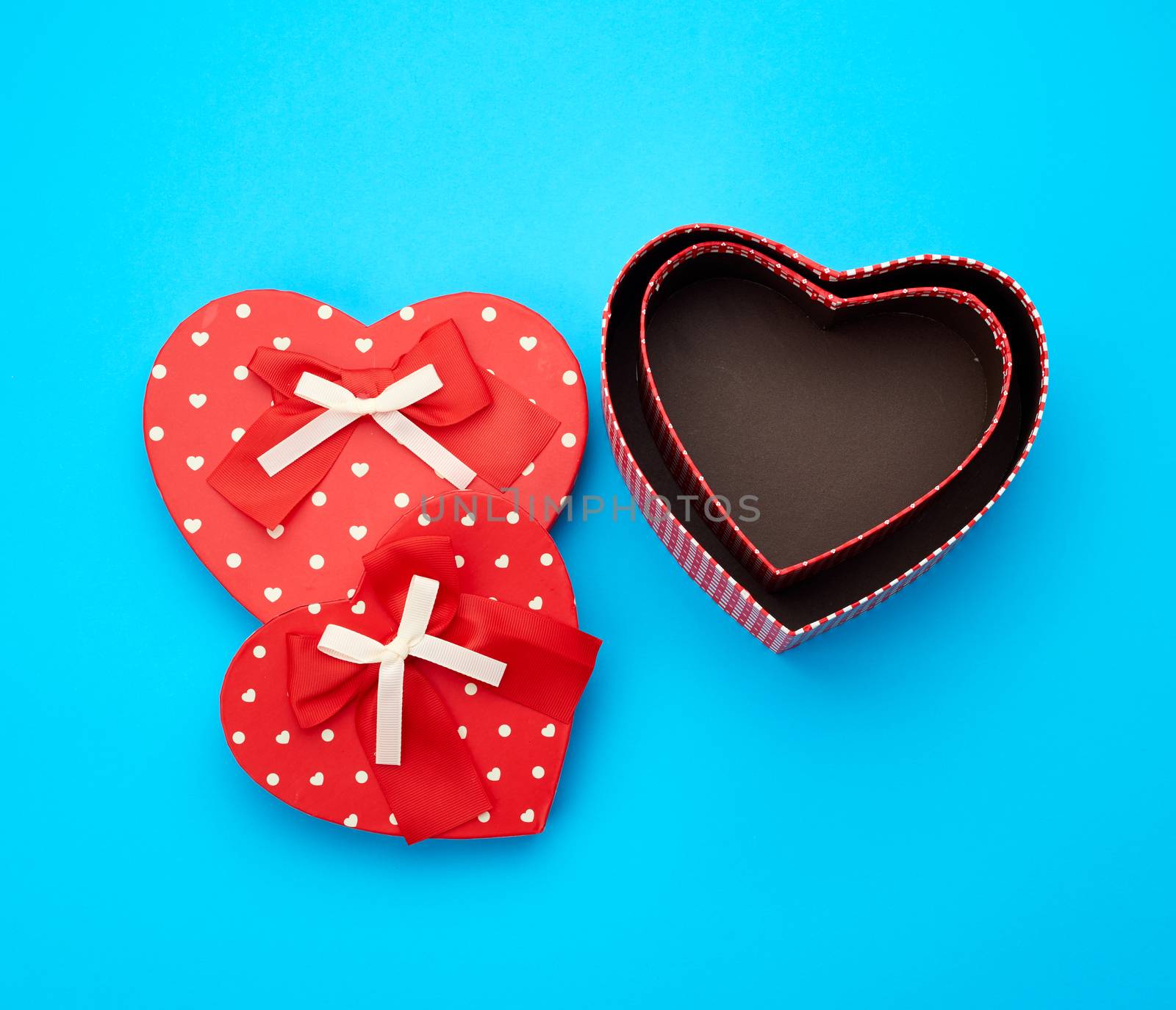 open empty red cardboard box in the form of a heart on a light blue background, top view, element for a designer
