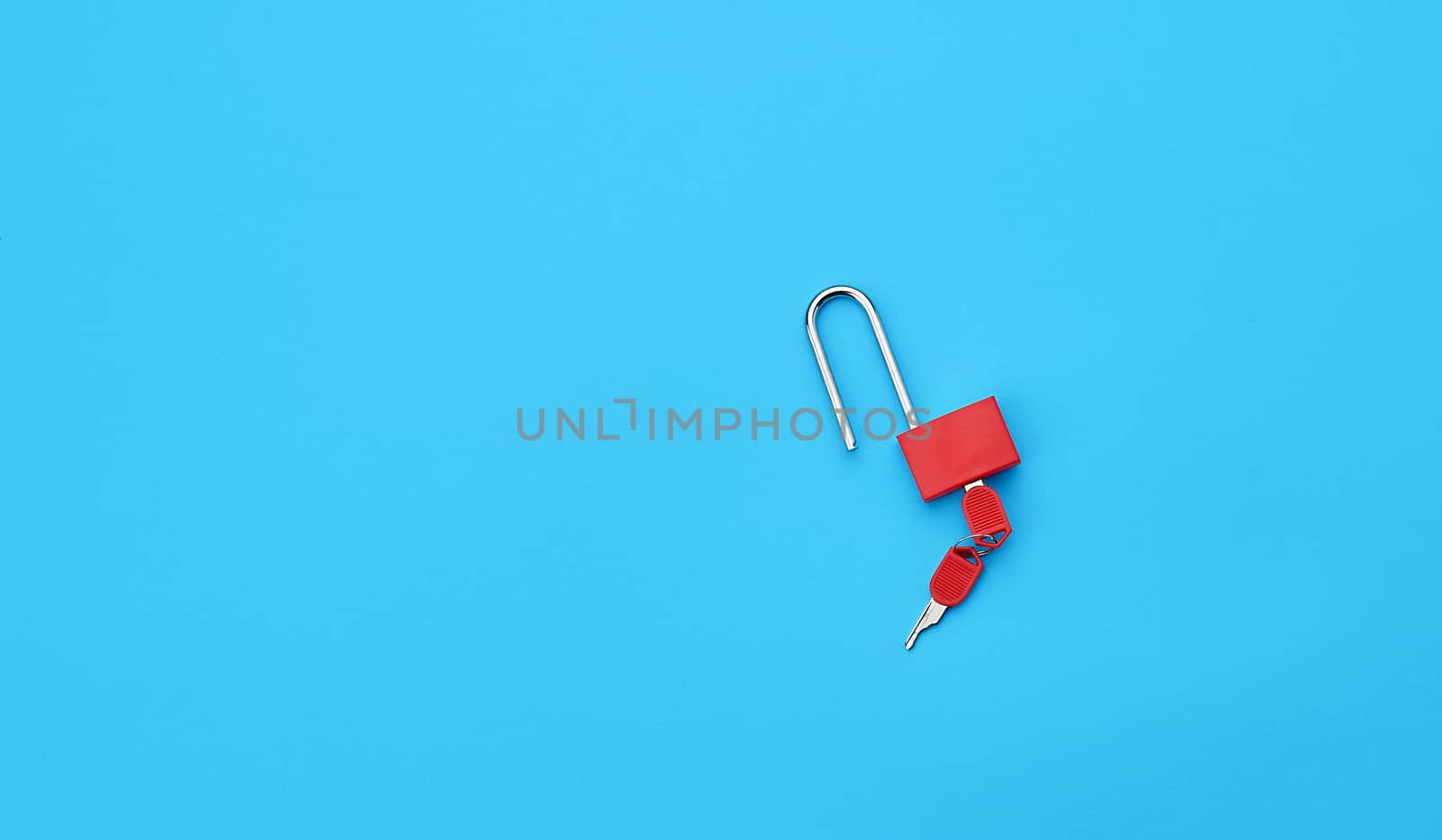 metal open padlock with keys on a blue background, copy space