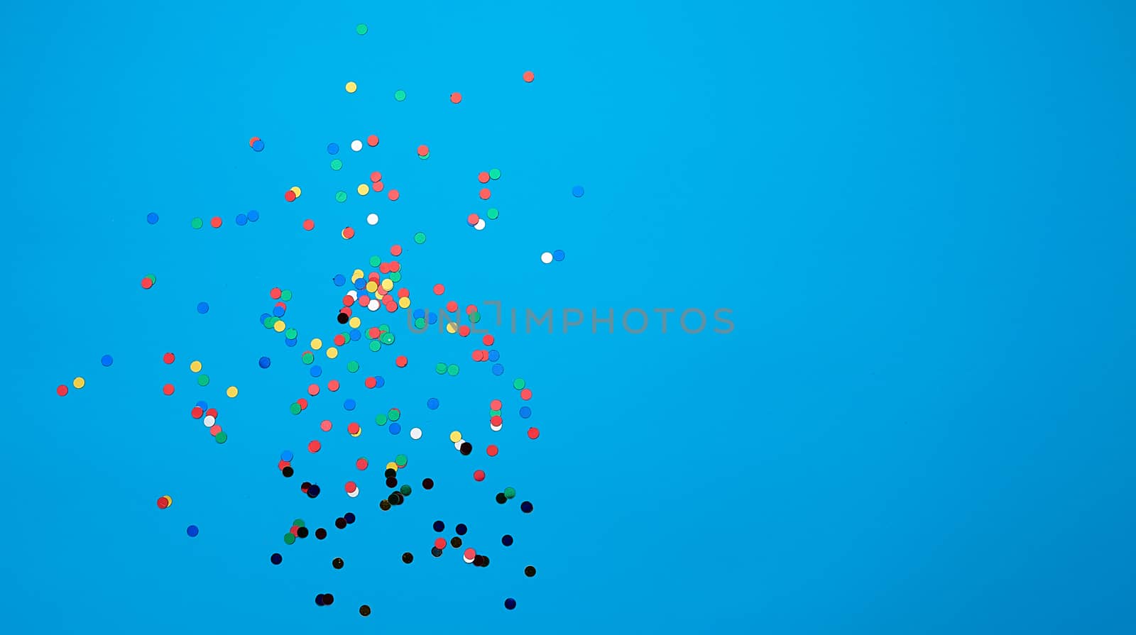 shiny multicolored round confetti scattered on a blue background, festive backdrop for birthday, valentines day. Festive decoration element. Flat design, copy space 