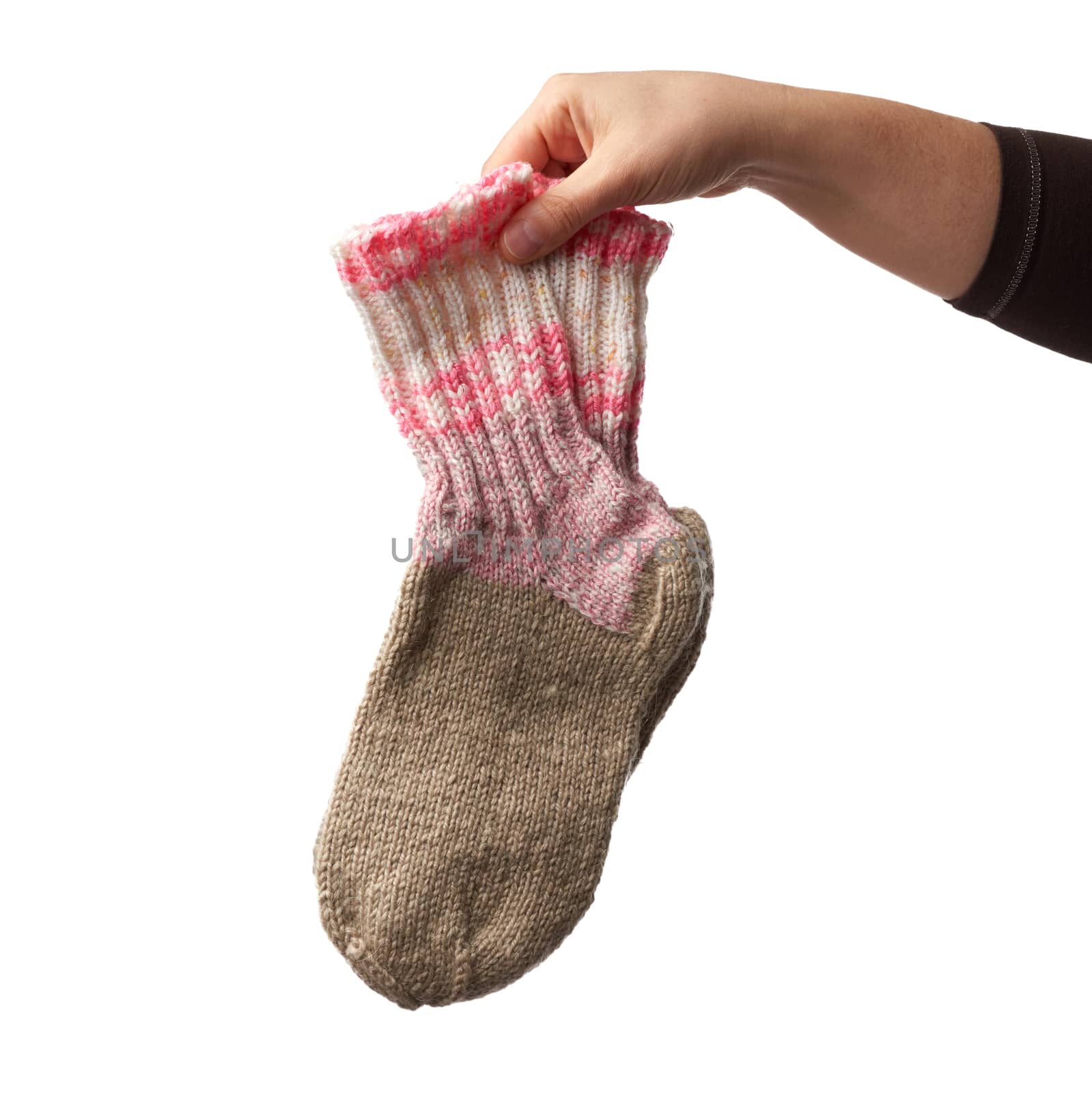 female hand holds a pair of knitted woolen socks, warm clothes, item is isolated on a white background 