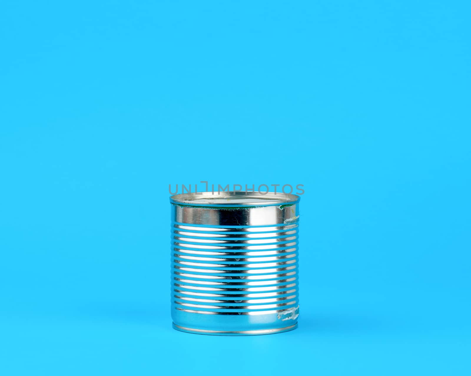 closed hard iron can for food preservation on a blue background, copy space