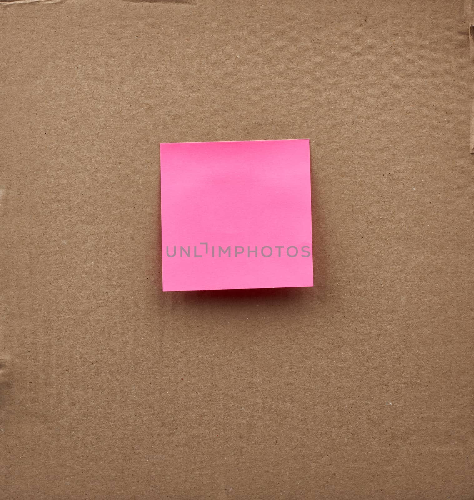 blank pink square paper glued on a brown cardboard surface. Design template.