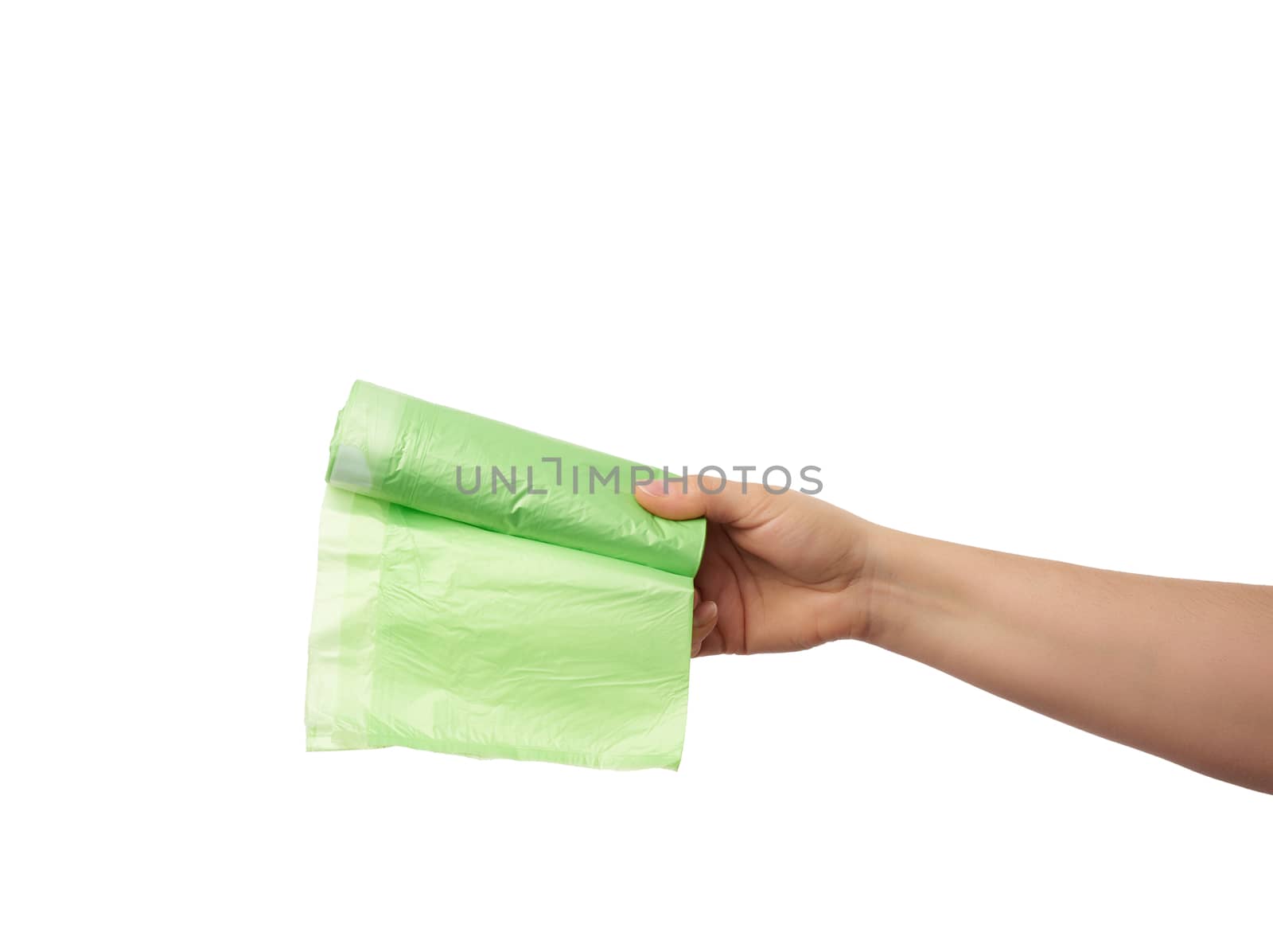 female hand holds a bundle of green plastic bags for garbage, part of the body with the subject isolated on a white background