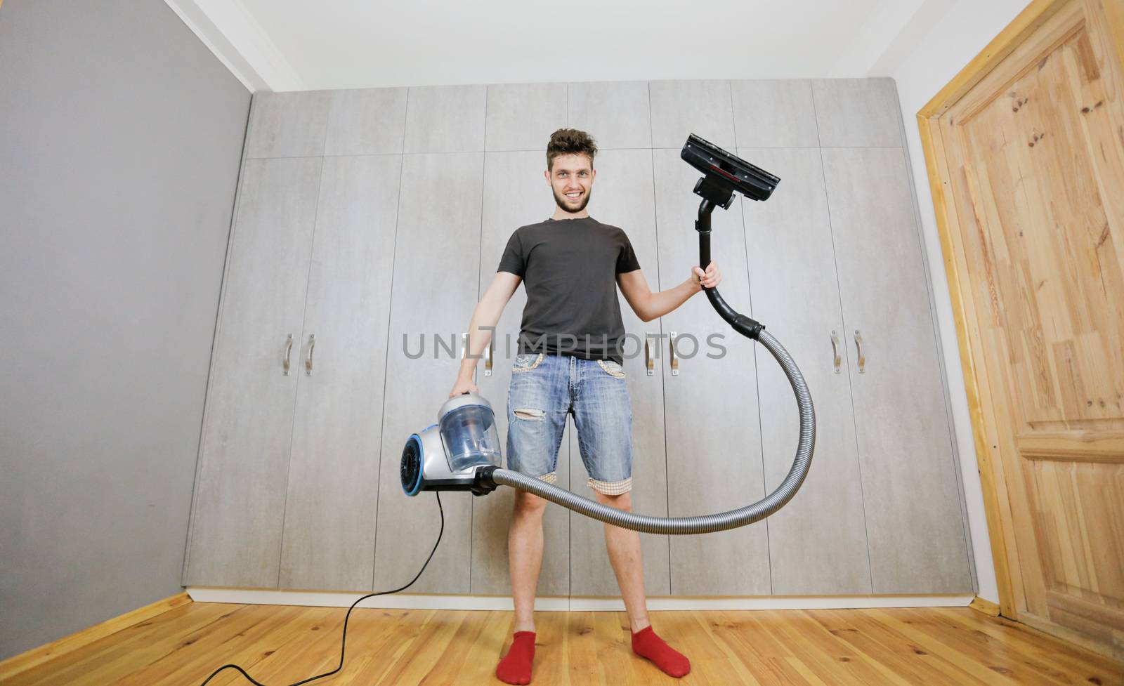 House cleaning. Man with a vacuum cleaner