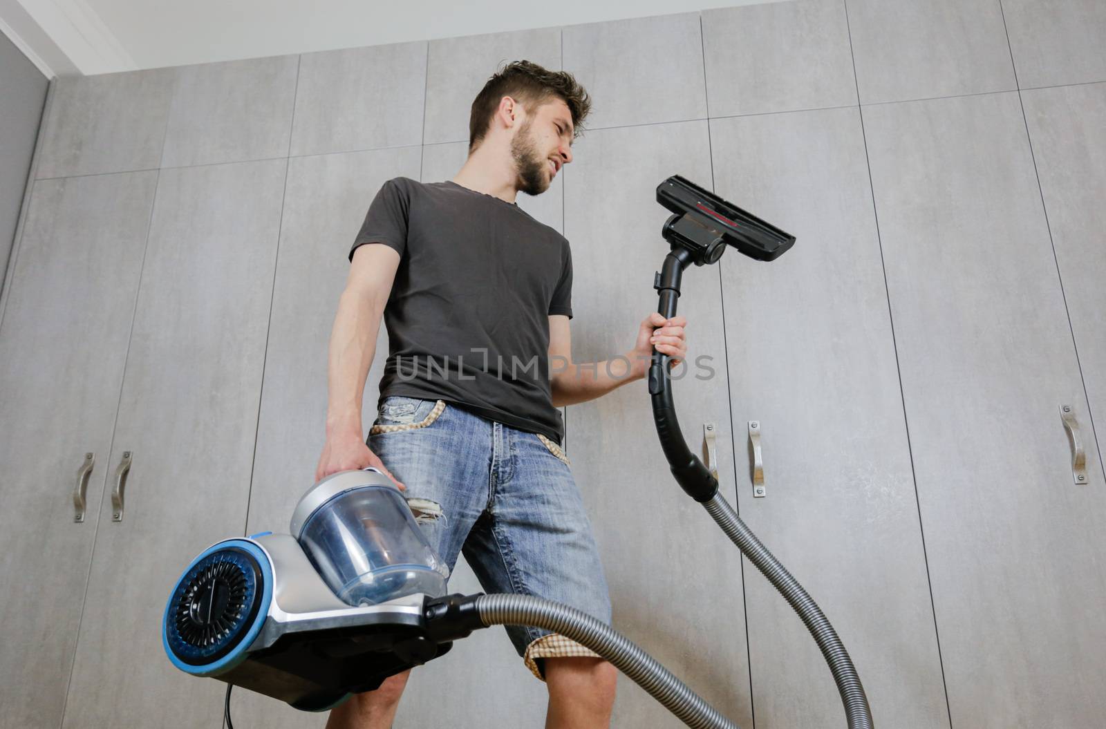 House cleaning. Man with a vacuum cleaner