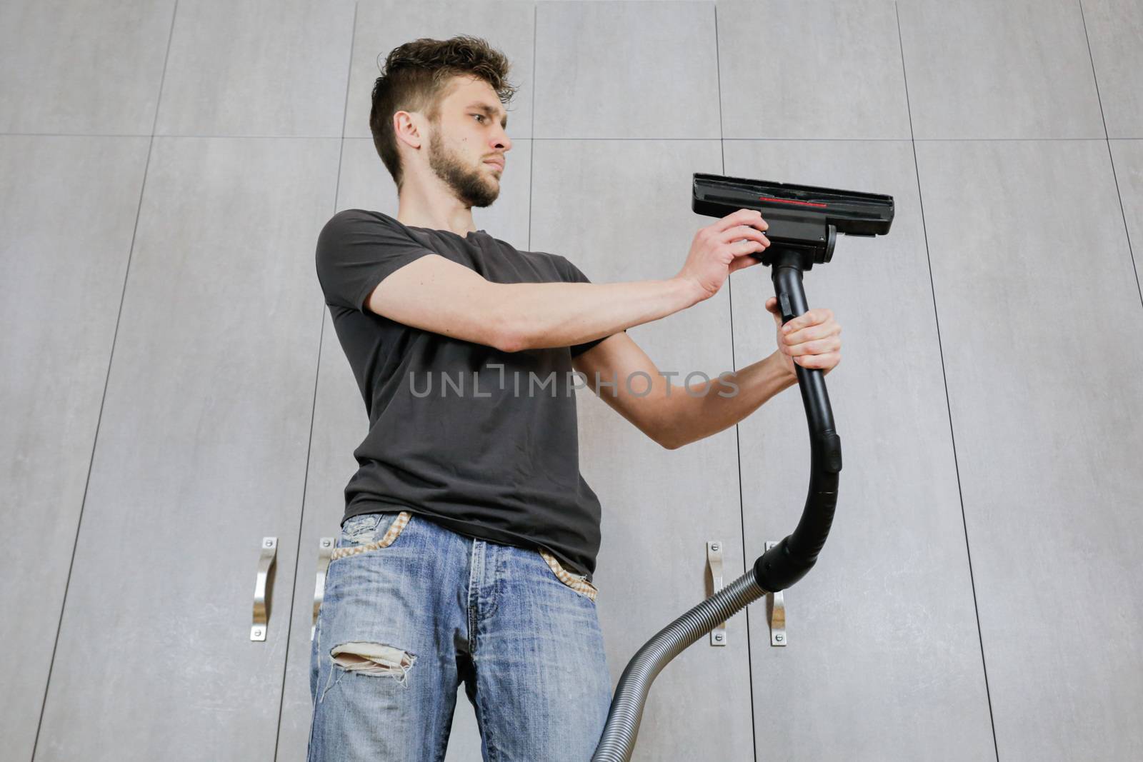 House cleaning. Man with a vacuum cleaner