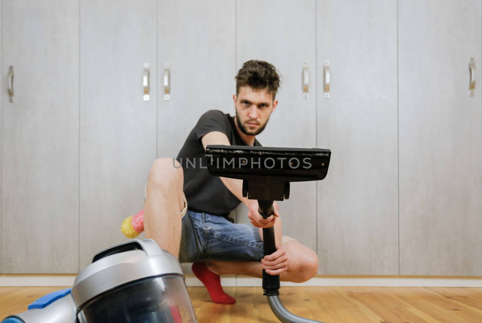 House cleaning. Man with a vacuum cleaner