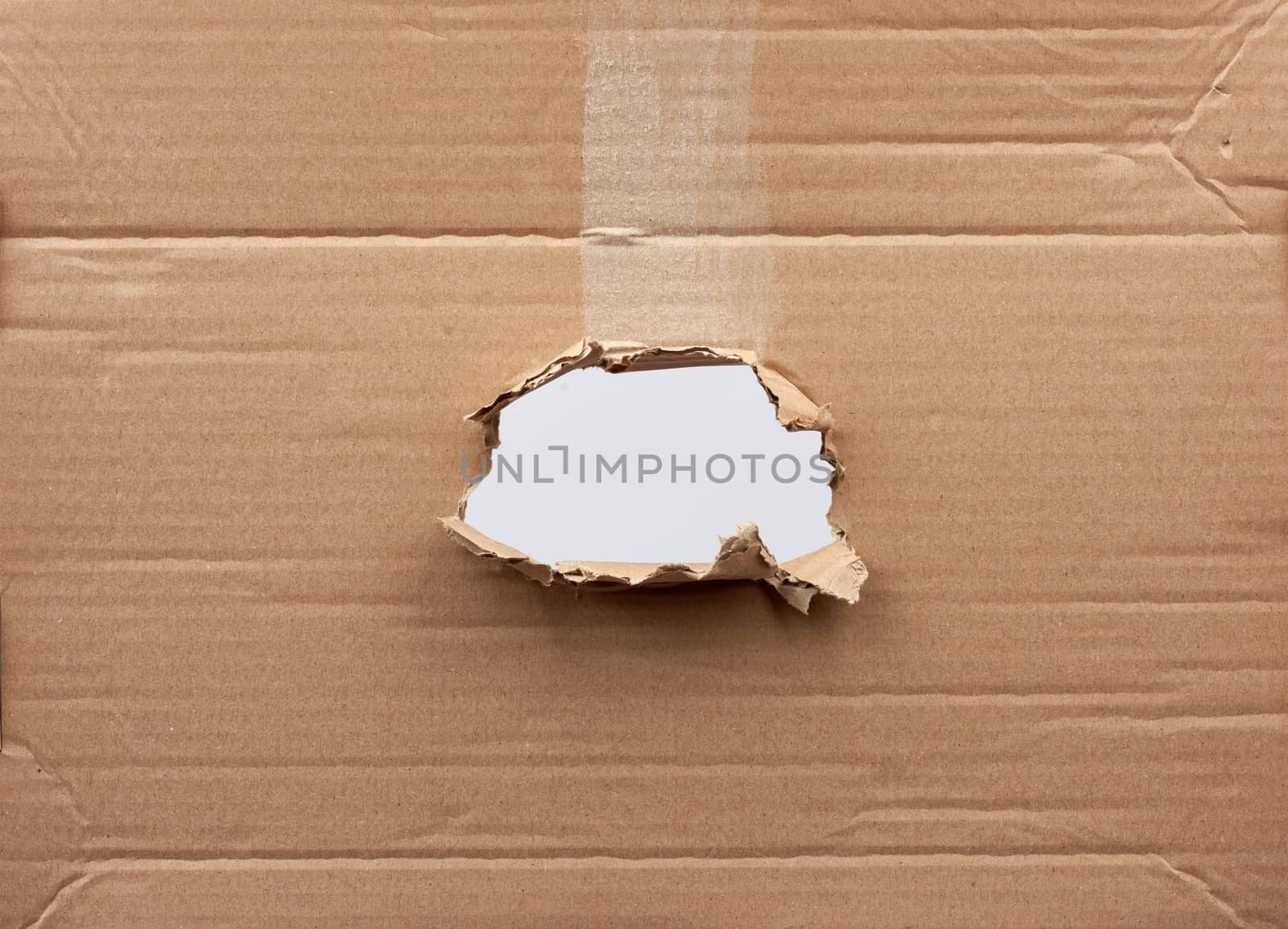 hole in brown cardboard paper with torn and curved edges. Blank template.