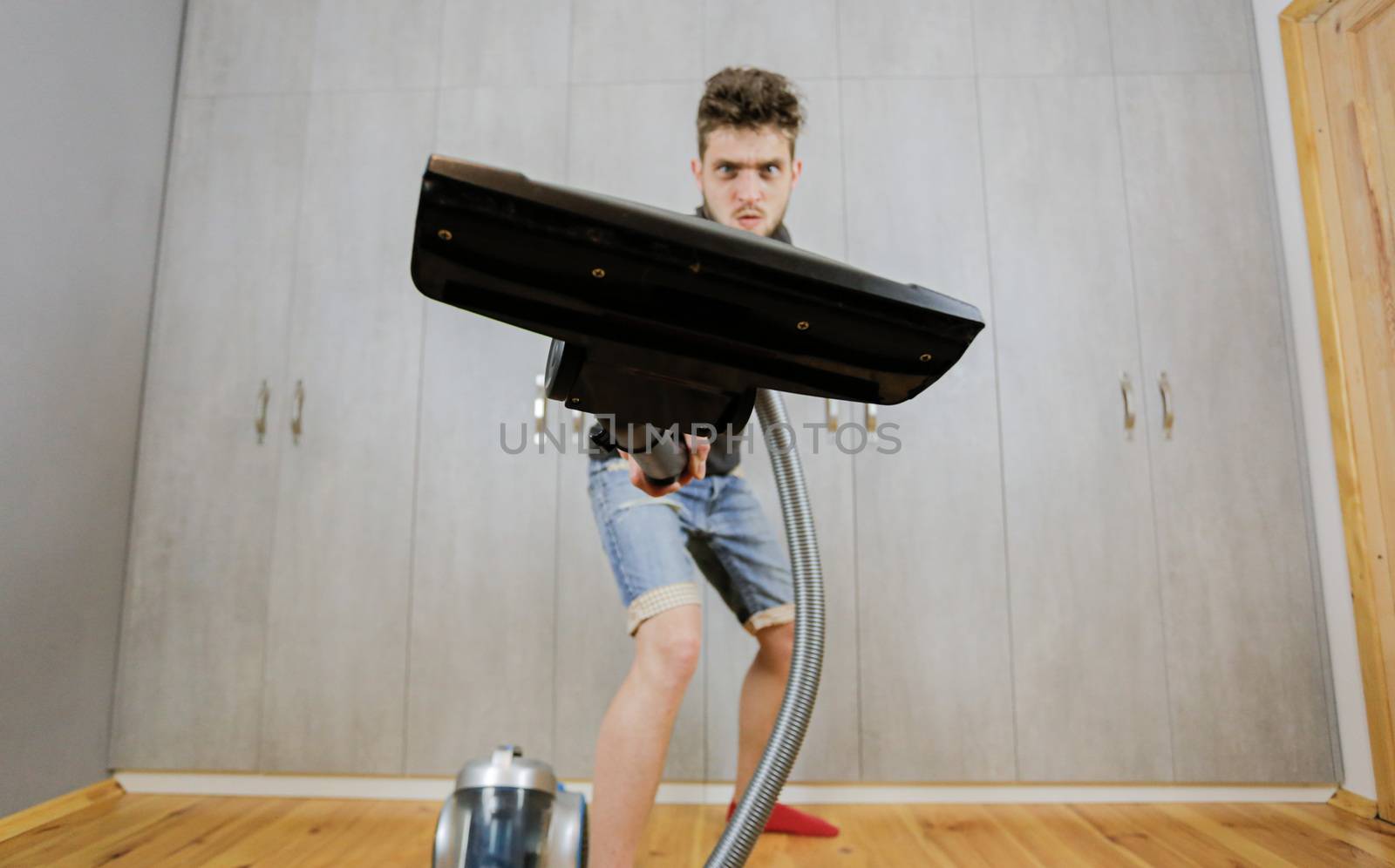 House cleaning. Man with a vacuum cleaner