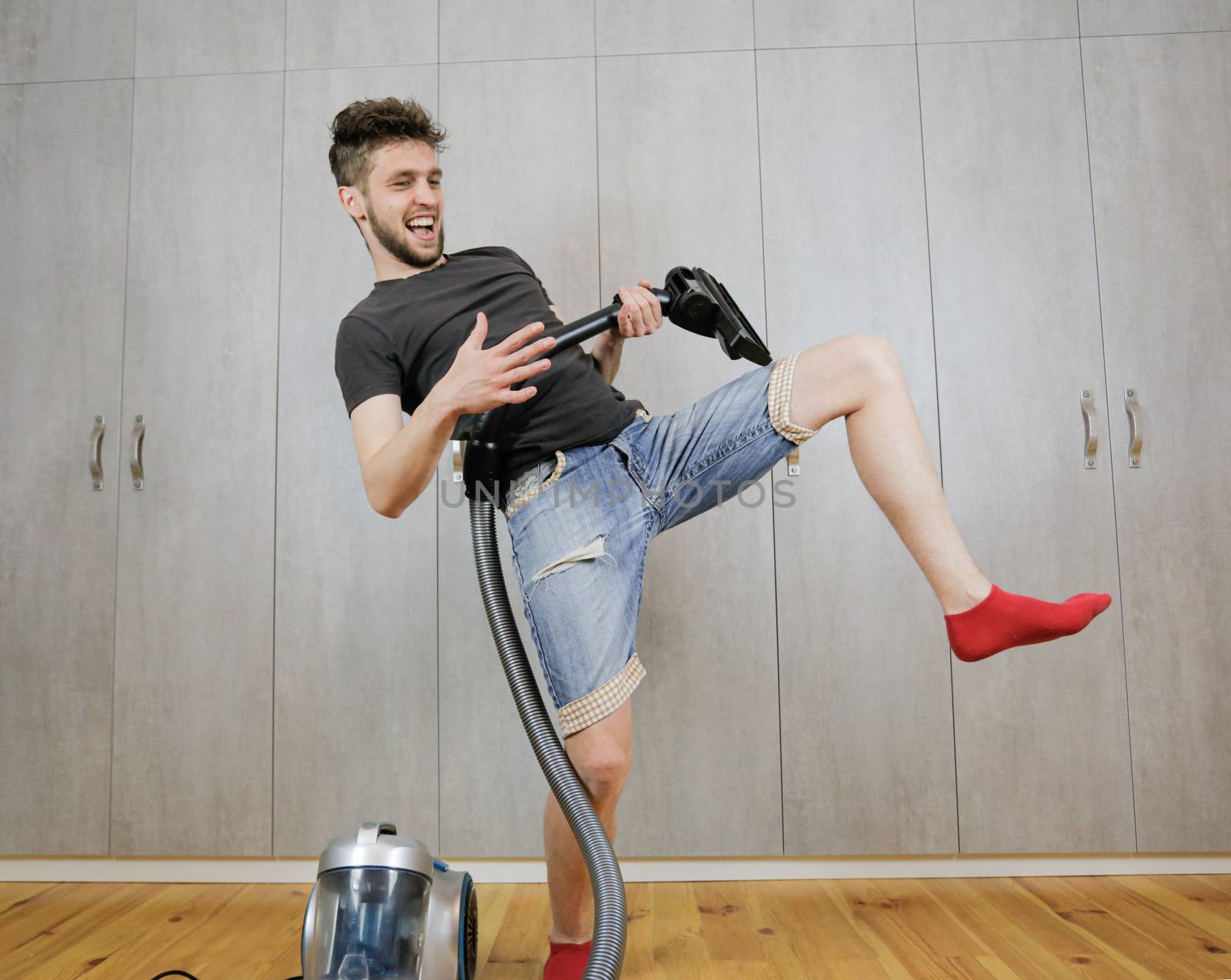 House cleaning. Man with a vacuum cleaner