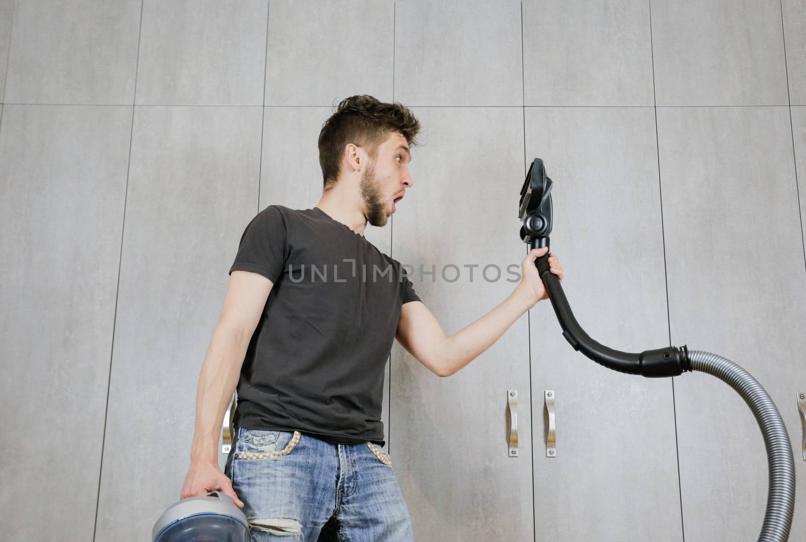 House cleaning. Man with a vacuum cleaner