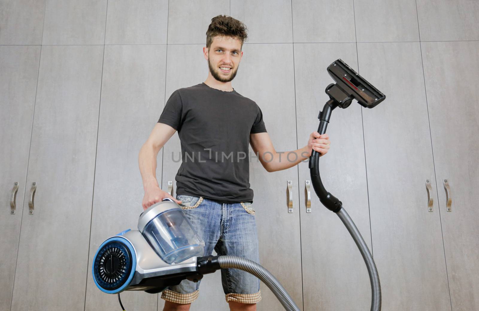 House cleaning. Man with a vacuum cleaner