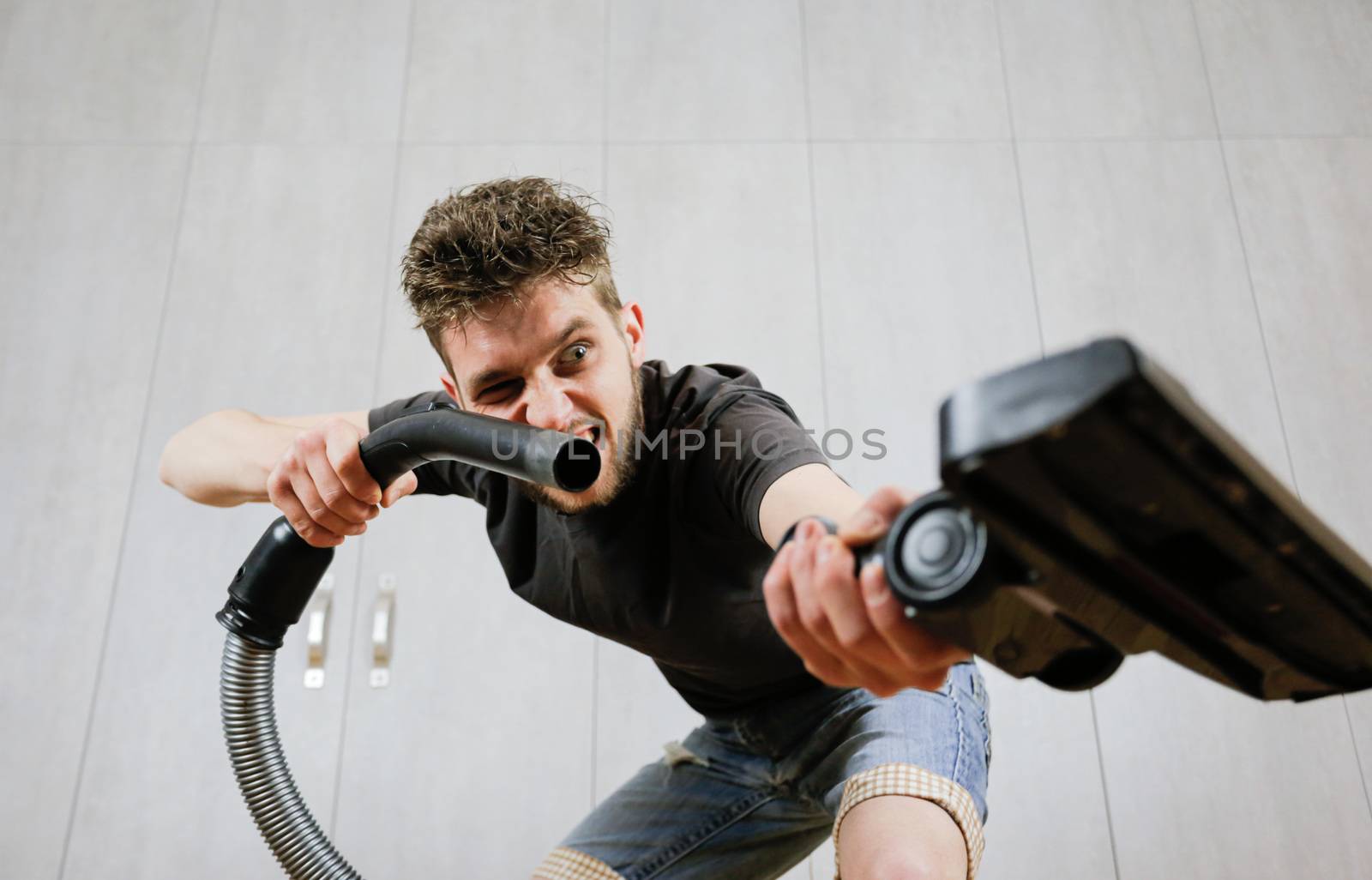 House cleaning. Man with a vacuum cleaner