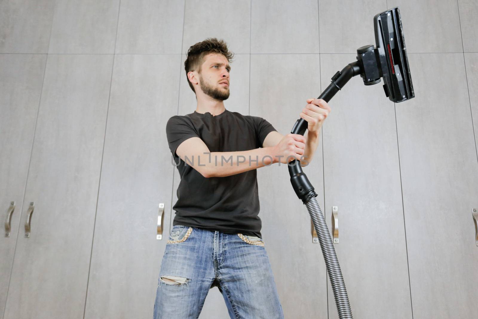 House cleaning. Man with a vacuum cleaner