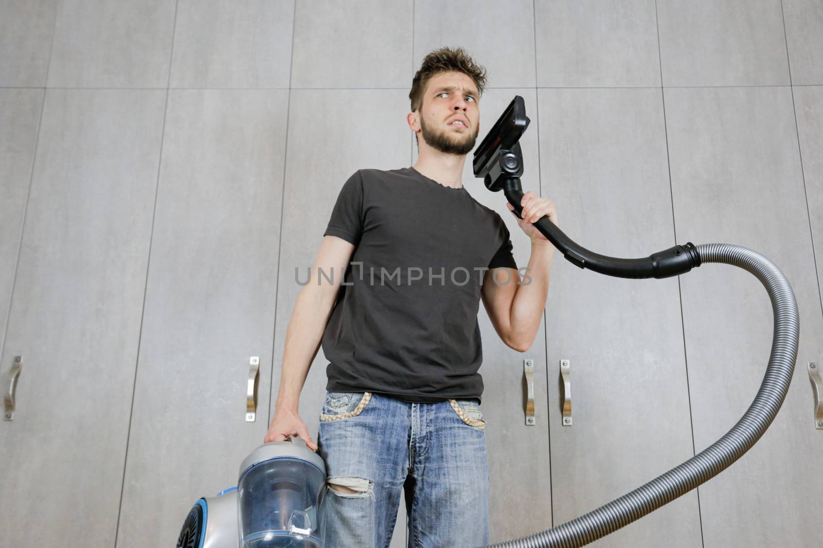 House cleaning. Man with a vacuum cleaner