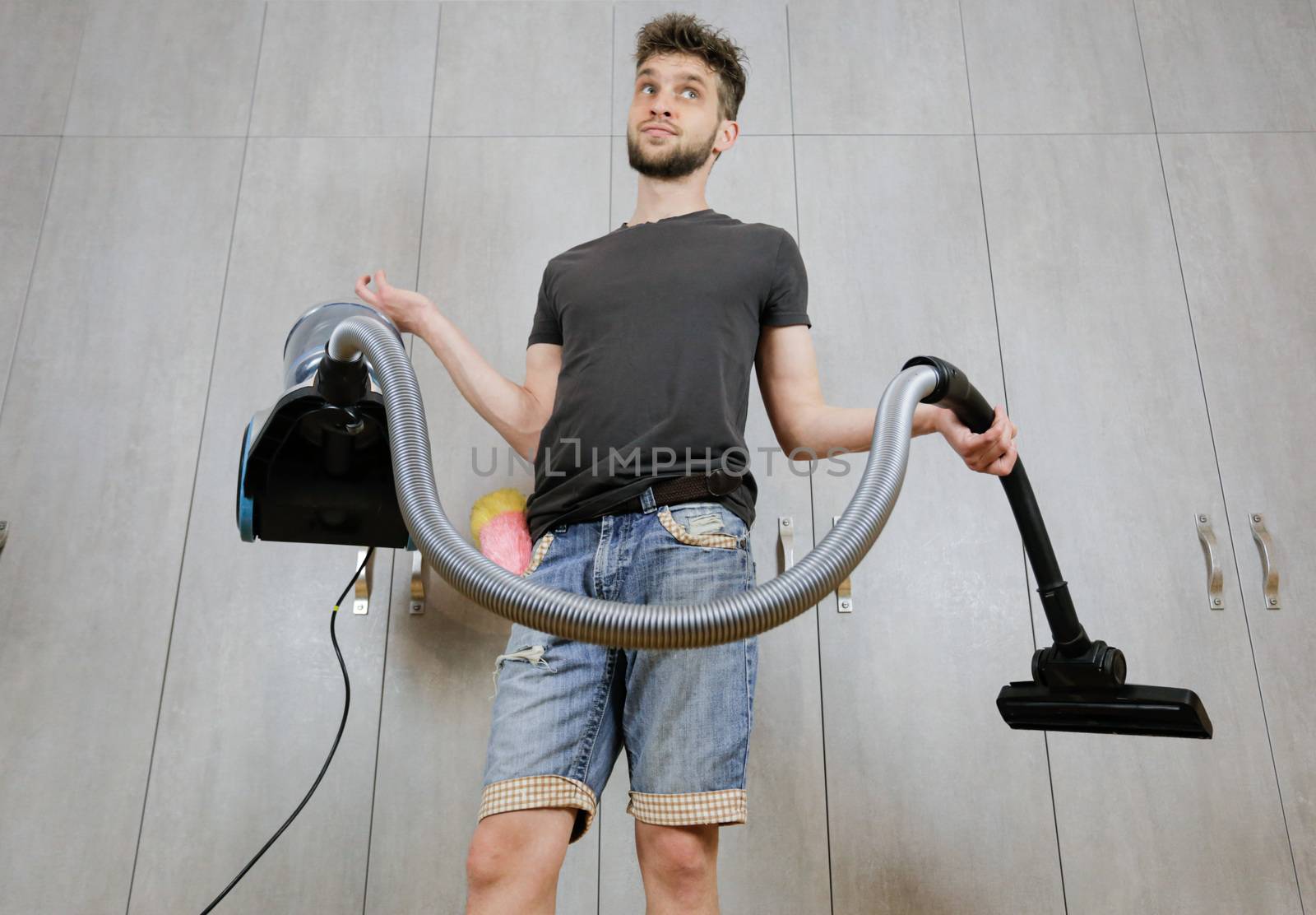 House cleaning. Man with a vacuum cleaner