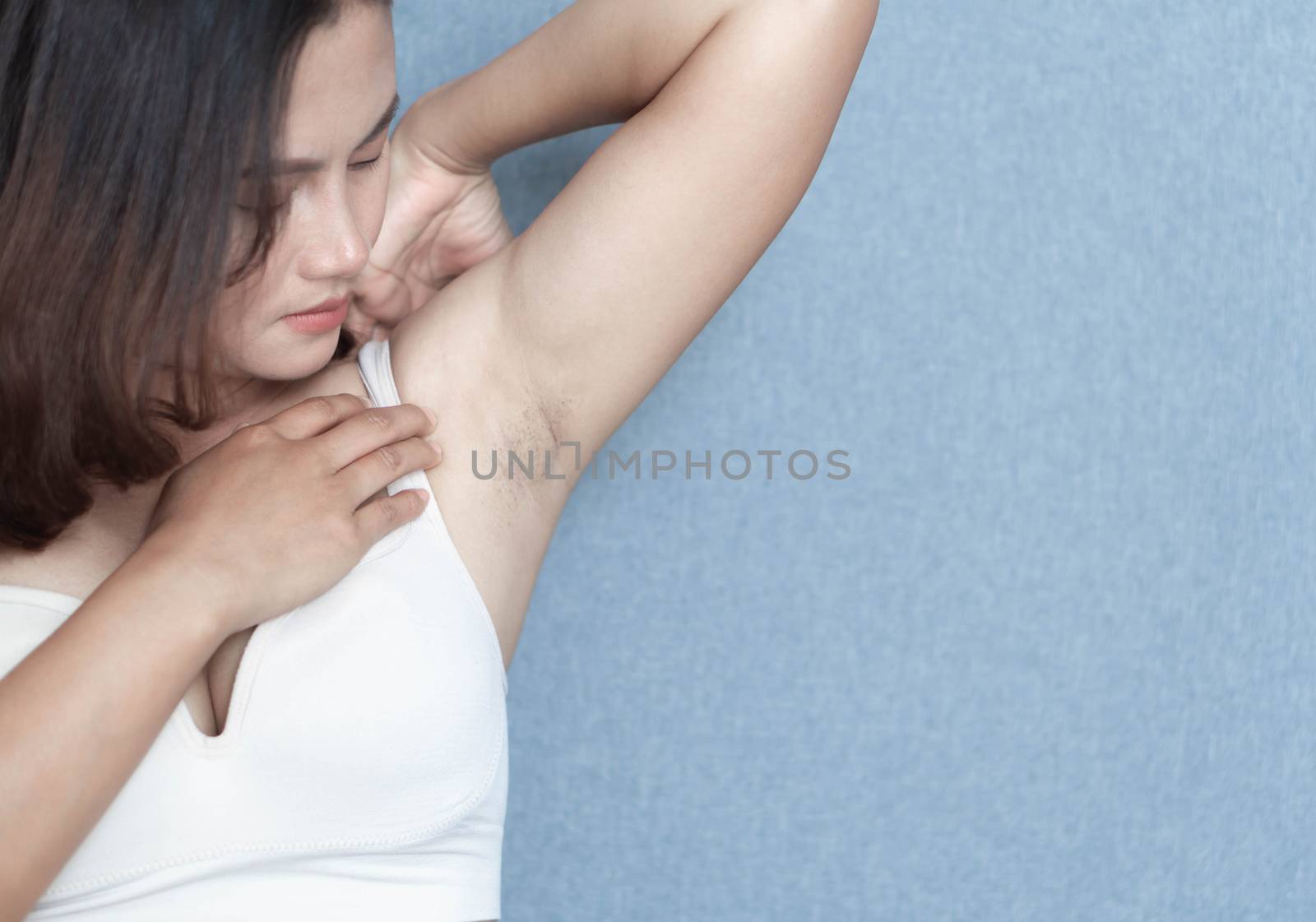 Women problem black armpit lying on white bed background for skin care and beauty concept, selective focus