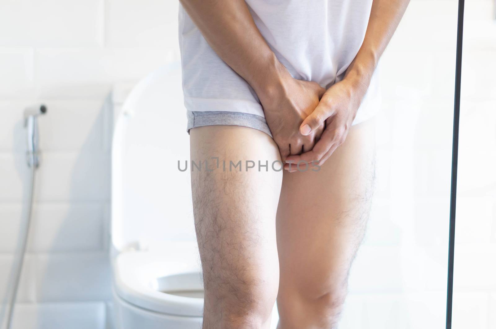 Closeup man holding bladder with pee pain in the toilet, selecti by pt.pongsak@gmail.com