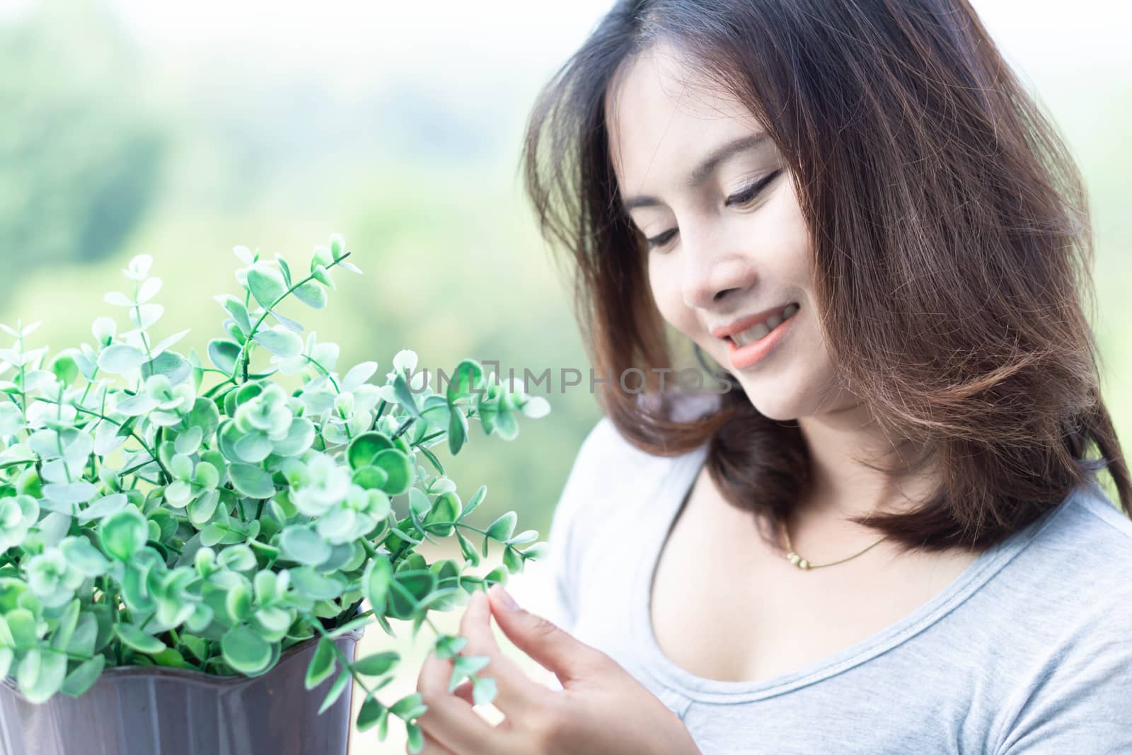 Closeup woman touching tree in pot with happy face in the mornin by pt.pongsak@gmail.com