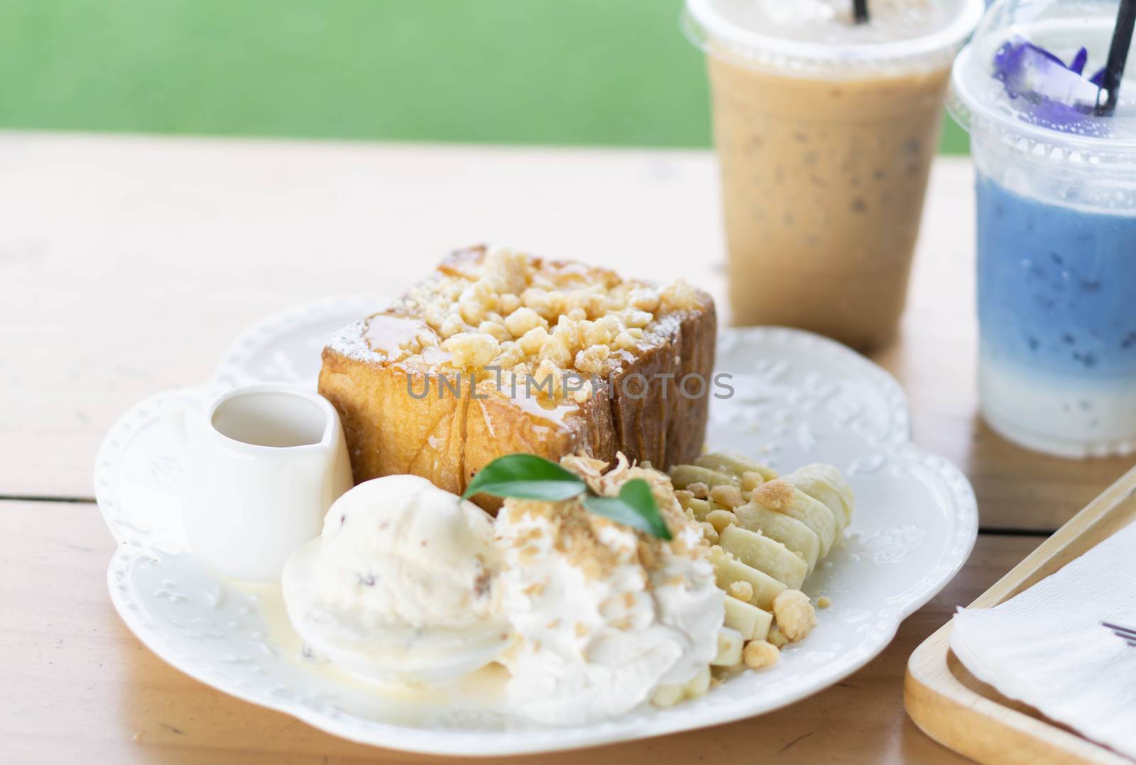Honey toast dessert with ice coffee and butterfly pea milk on wood table, top view