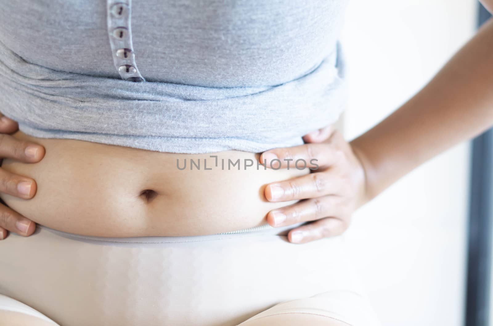 Closeup hand holding abdominal surface woman fat, healthy care and beauty concept