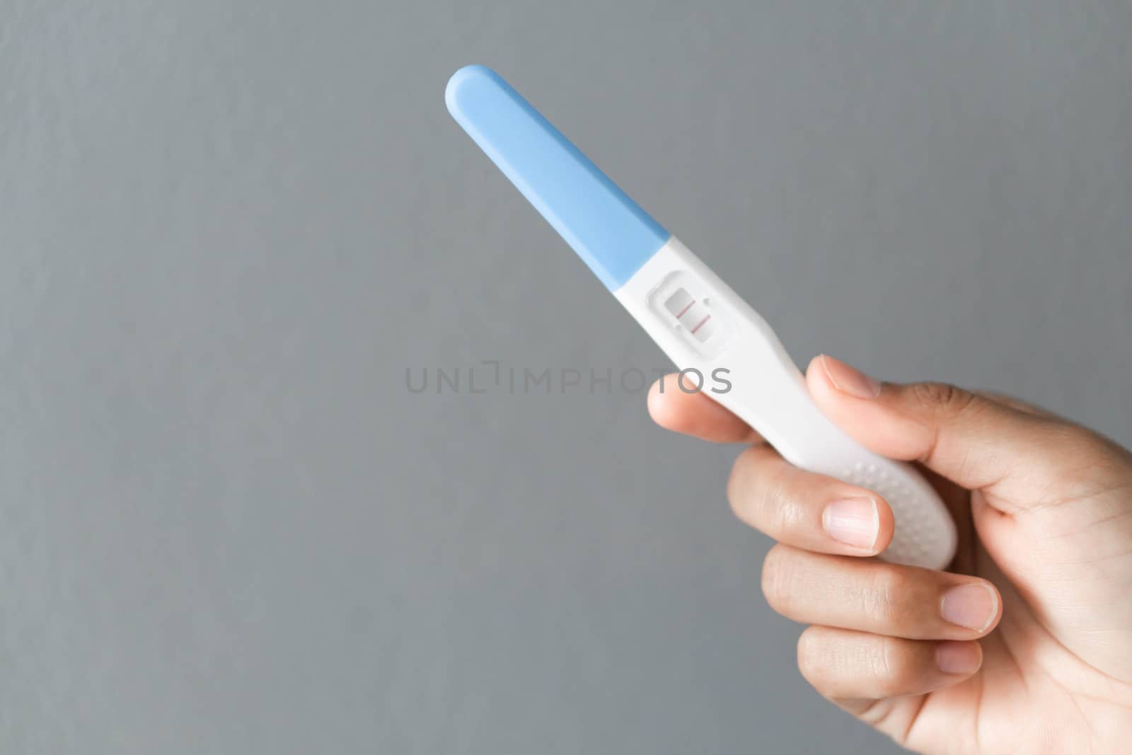 Closeup woman hand holding pregnancy test with happy moment, health care concept, selective focus