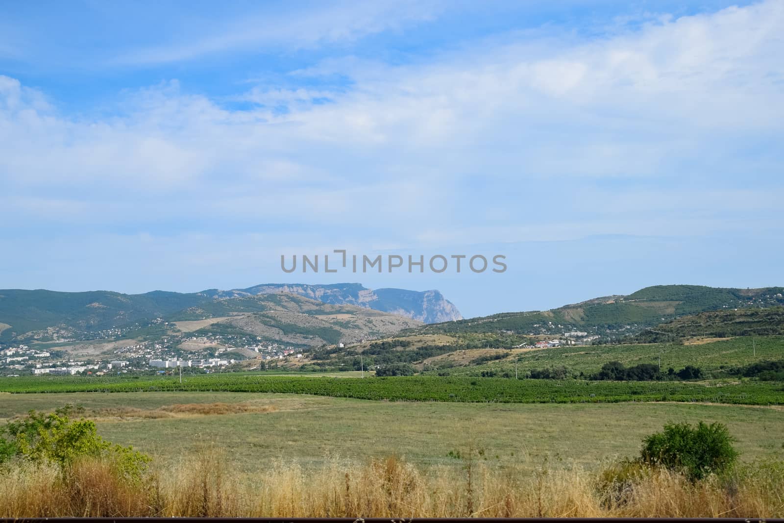 Landscapes of Crimean nature. Fields and hills visible from car window from the road.