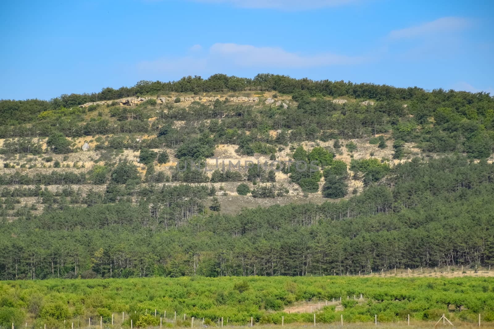 Landscapes of Crimean nature. Fields and hills visible from car window from the road.