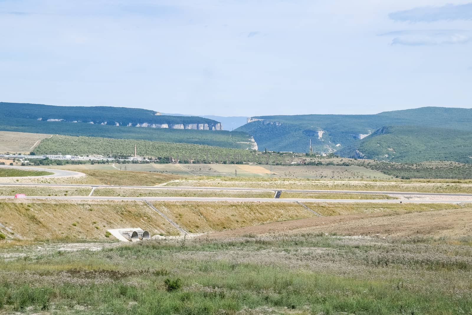 Landscapes of Crimean nature. Fields and hills visible from car window from the road.