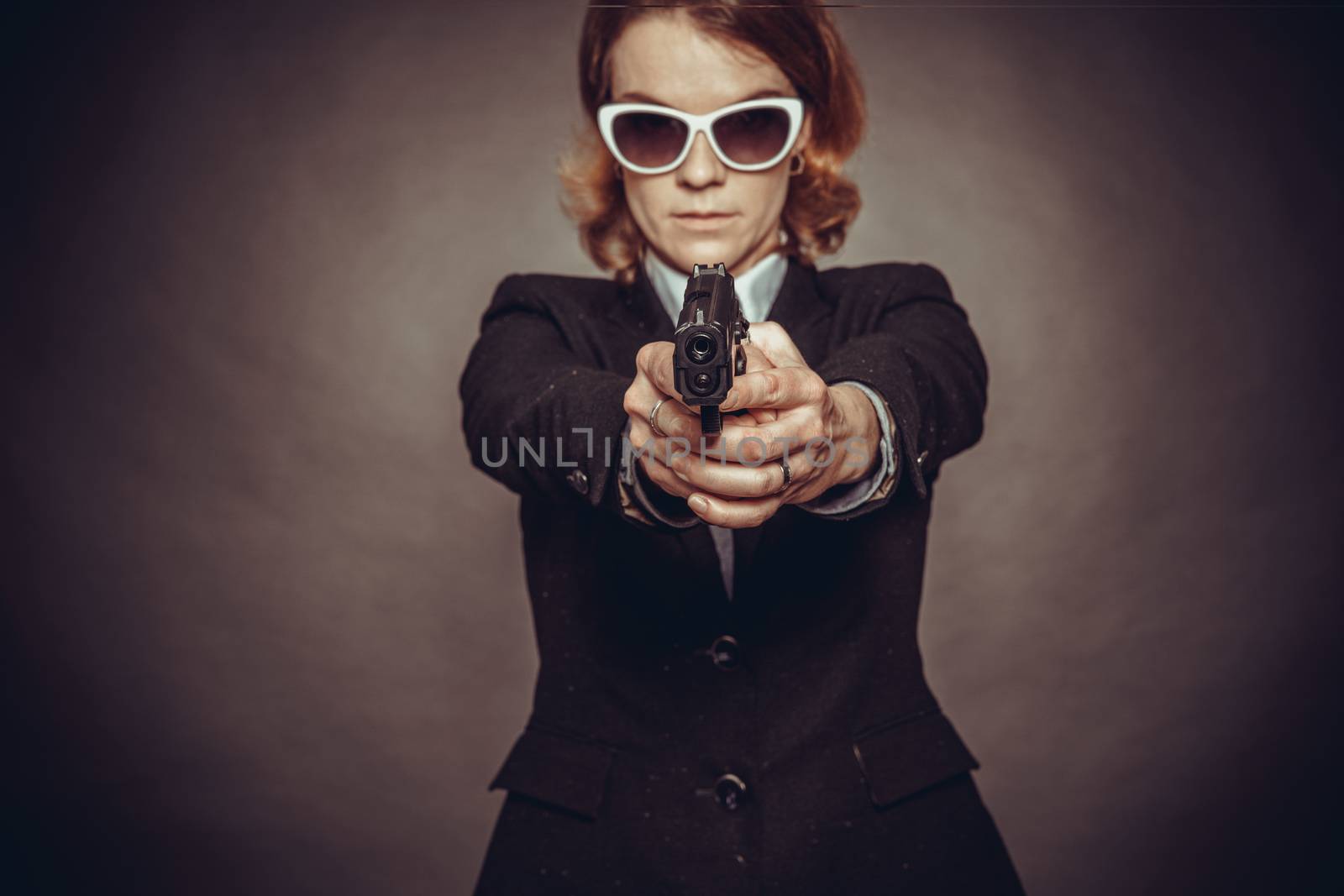 aiming weapon woman in suit. dangerous situation, endangerment by Edophoto