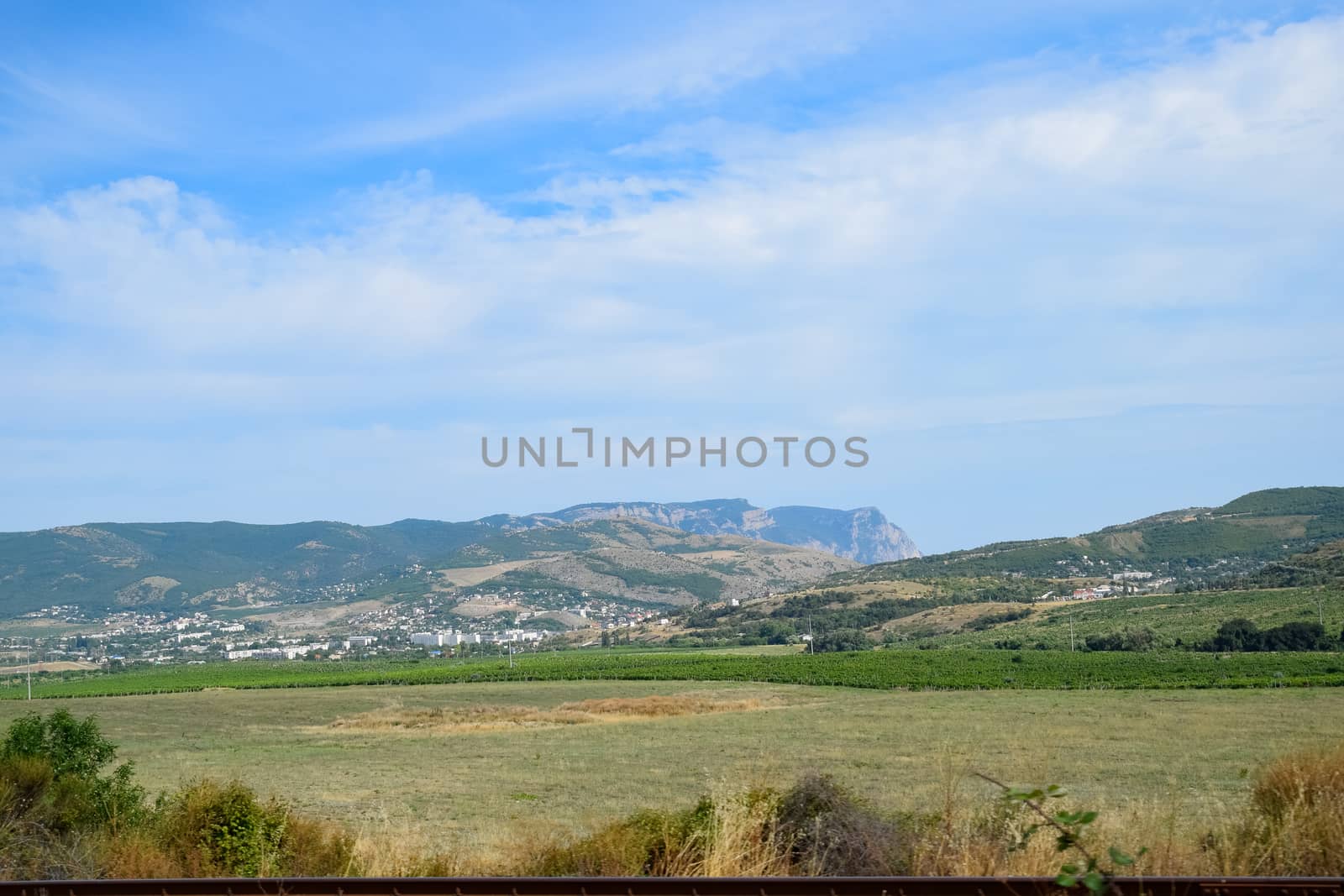 Landscapes of Crimean nature. Fields and hills visible from car window from the road.